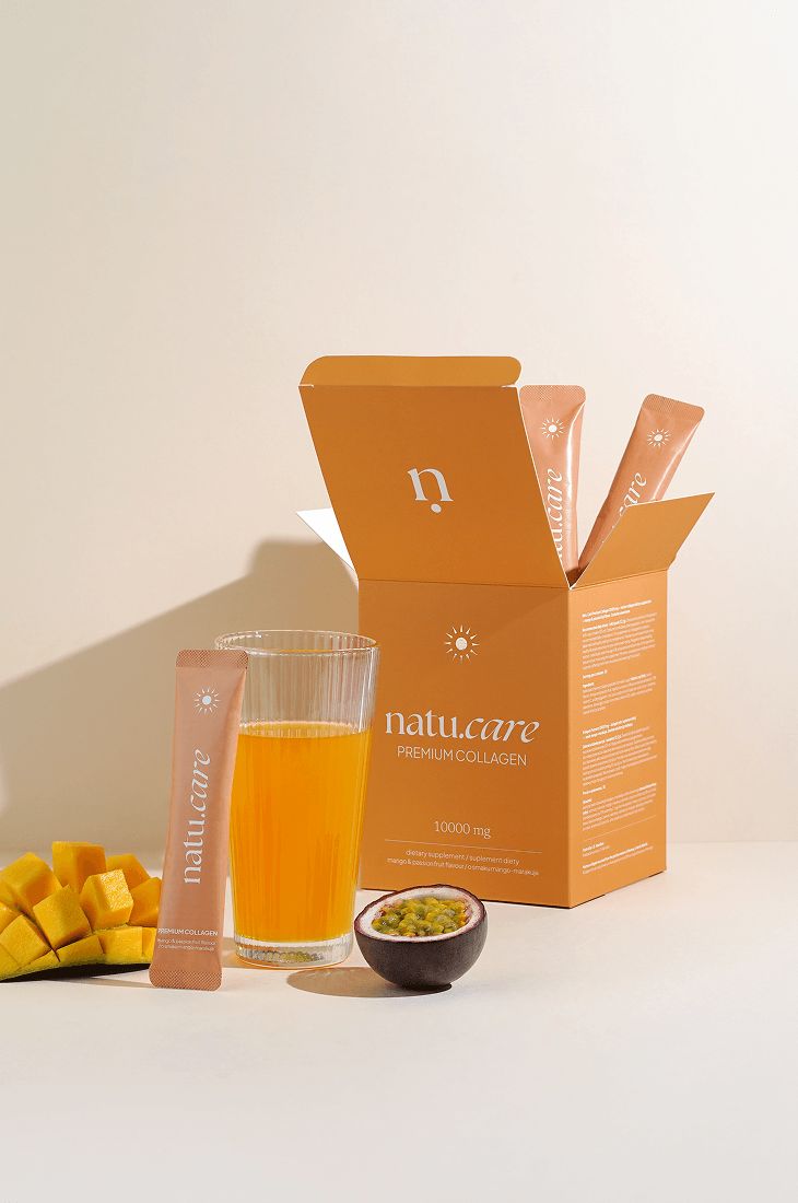 Geöffnete Schachtel mit Beuteln. Glas mit Flüssigkeit, Mango, Maracuja. Aufschrift "natu.care".