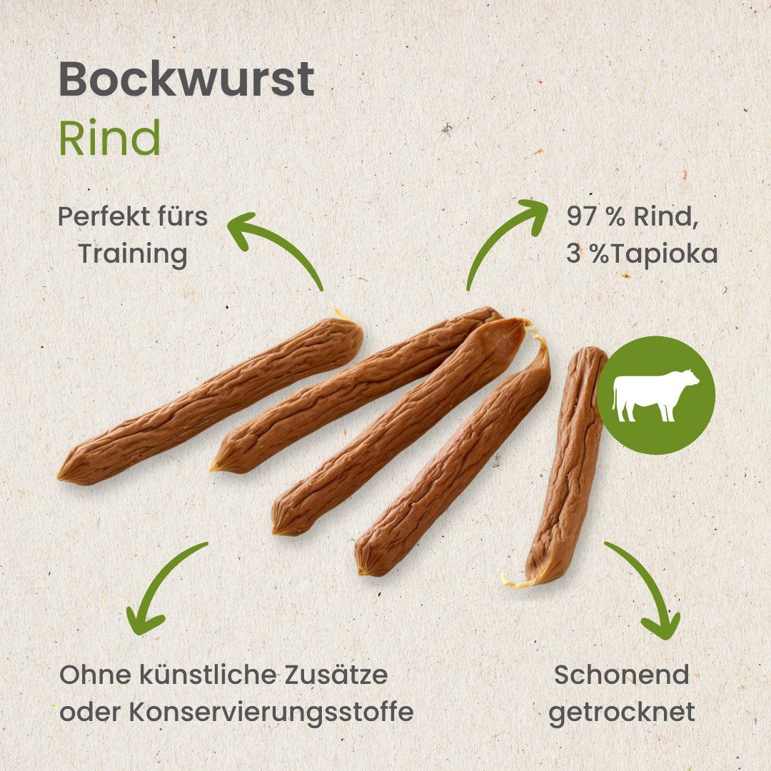 Haufen von kleinen, braunen, zylindrischen Hundeleckerlis auf weißem Hintergrund.