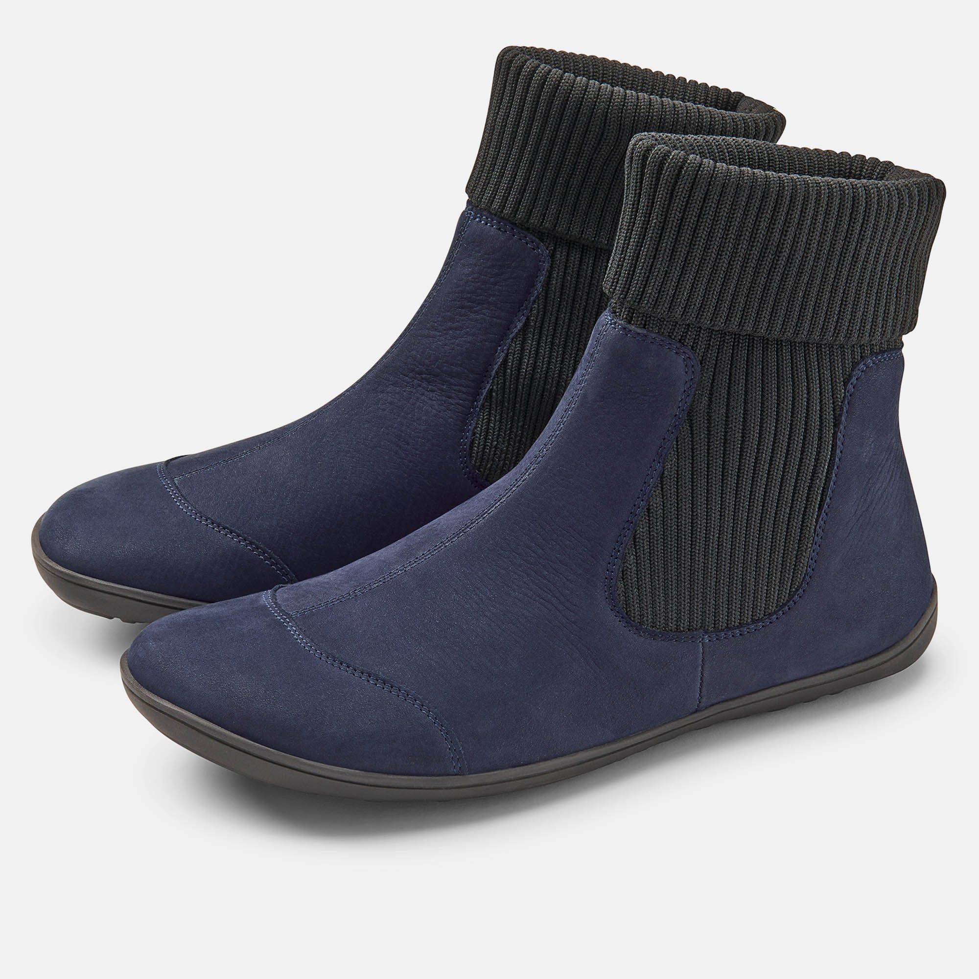 Zwei blaue Stiefeletten mit schwarzem, geripptem Schaft. Flache Sohle, aus Leder.