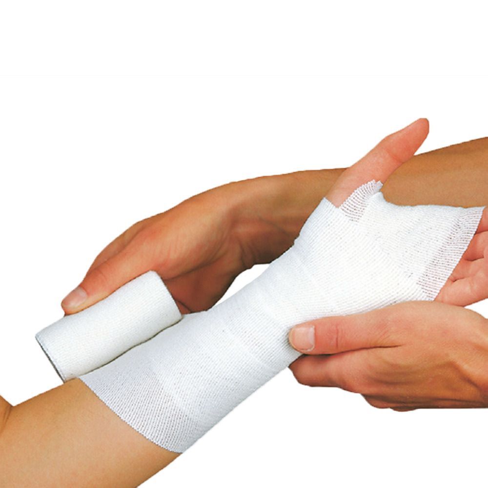 Weißes Verbandmaterial wird auf einem Arm angebracht. Eine Rolle Verbandmaterial liegt daneben. Hände halten den Arm.
