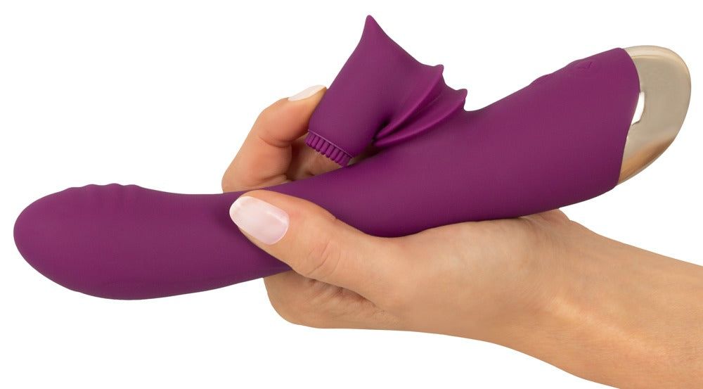 Lila Vibrator in Hand gehalten. Mit beweglichem Stimulator und goldfarbener Spitze. Teilweise in Hand gehalten.