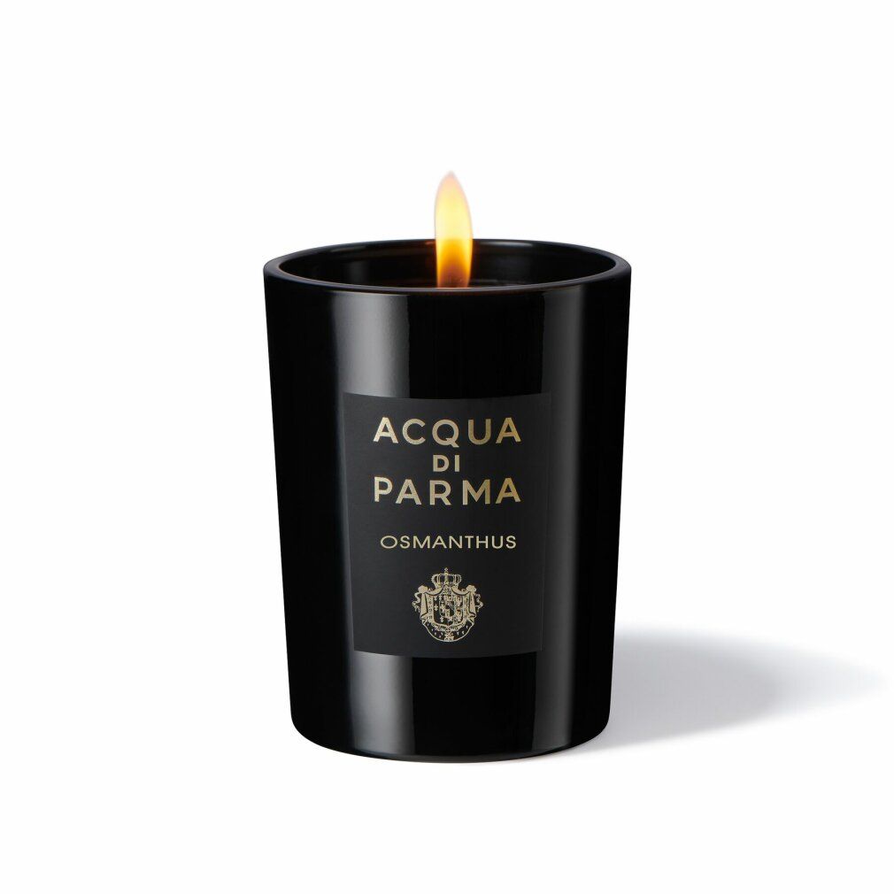 Schwarze Kerze mit Flamme. Aufschrift: Acqua di Parma, Osmanthus. Logo. Kerze in Glas. Brennende Flamme.