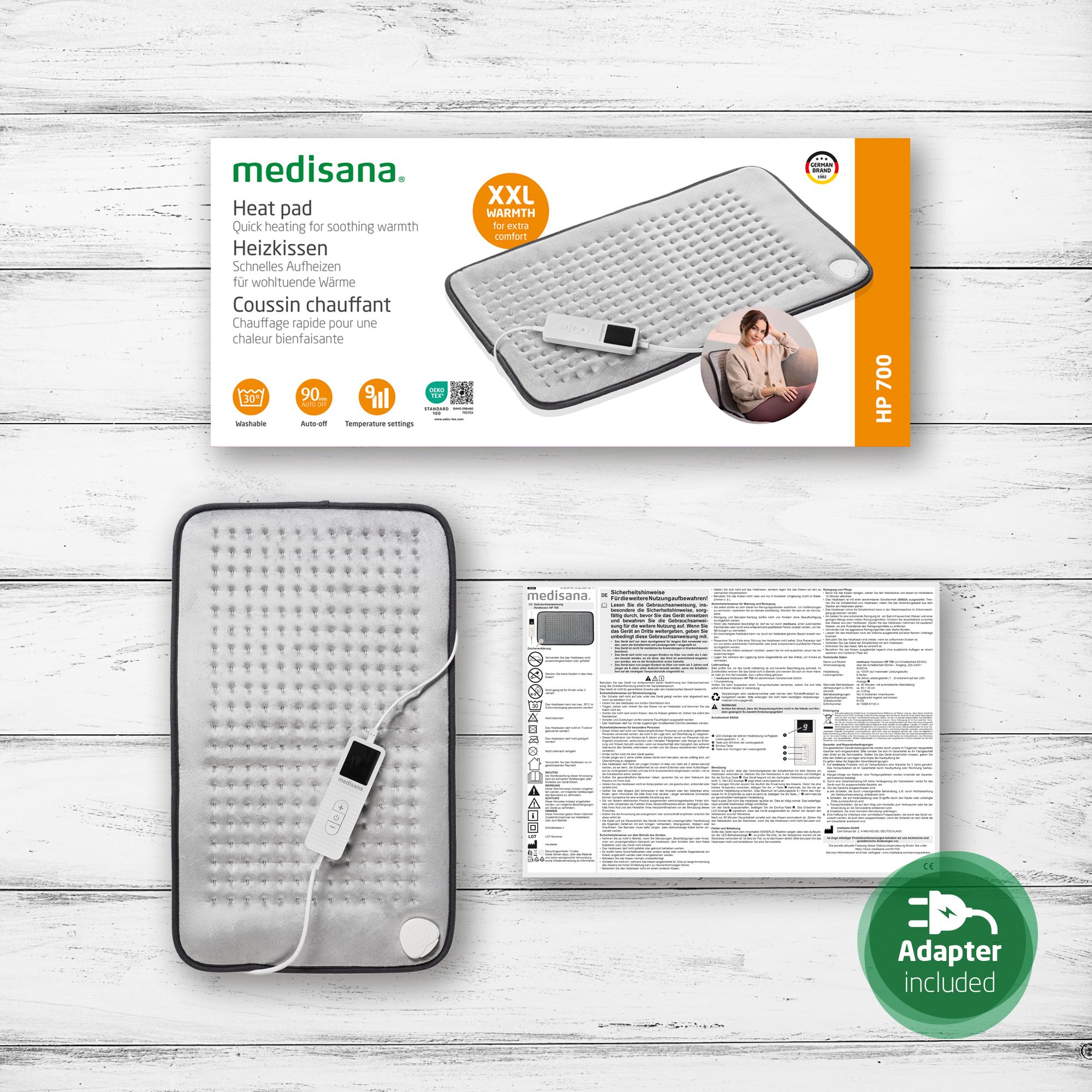 Produktverpackung und Heizkissen. Verpackung zeigt Heizkissen, Text: medisana, HP 700. Adapter enthalten.