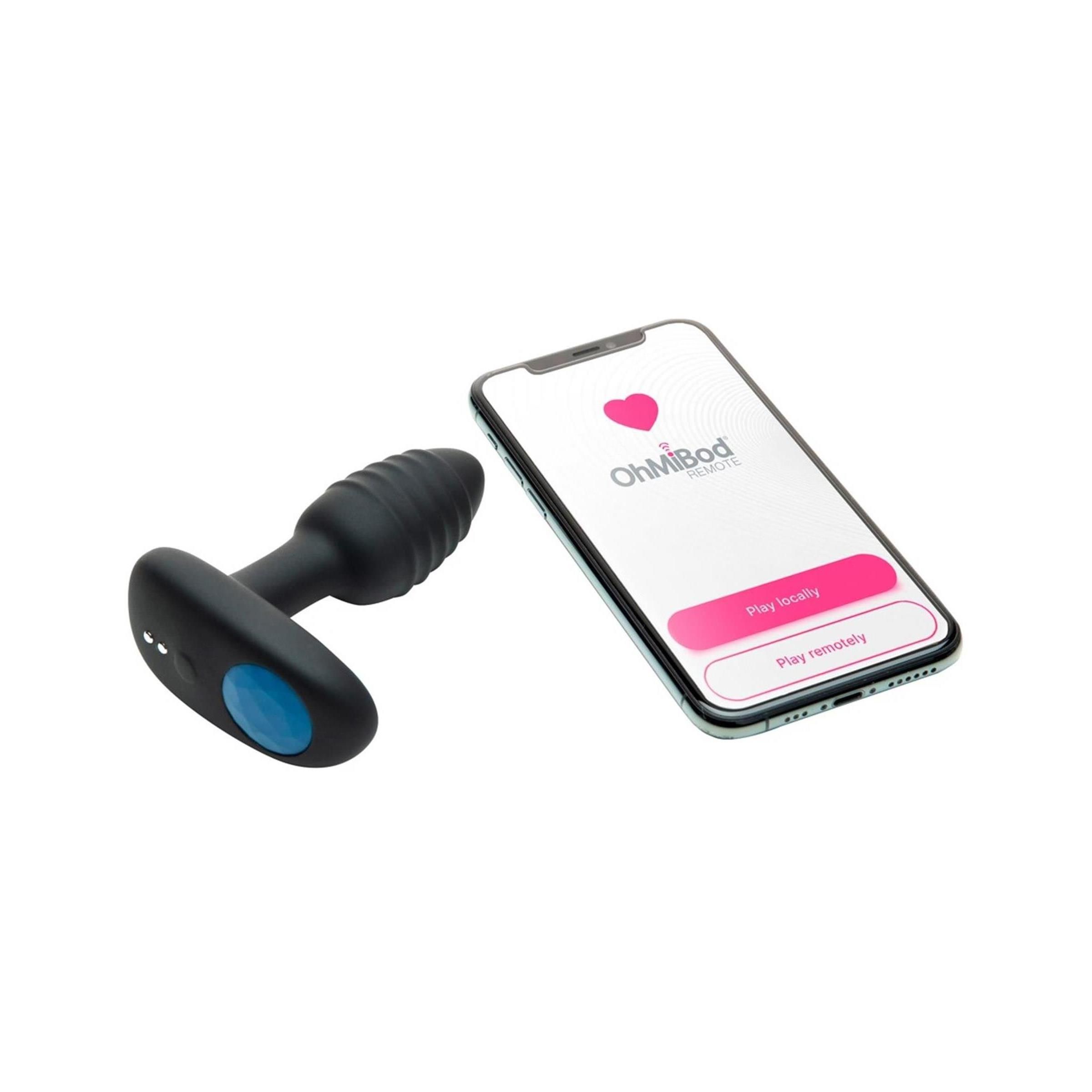 Schwarzes Wellness-Produkt mit geriffelter Spitze und ovalem Griff, neben einem Smartphone mit App-Anzeige.