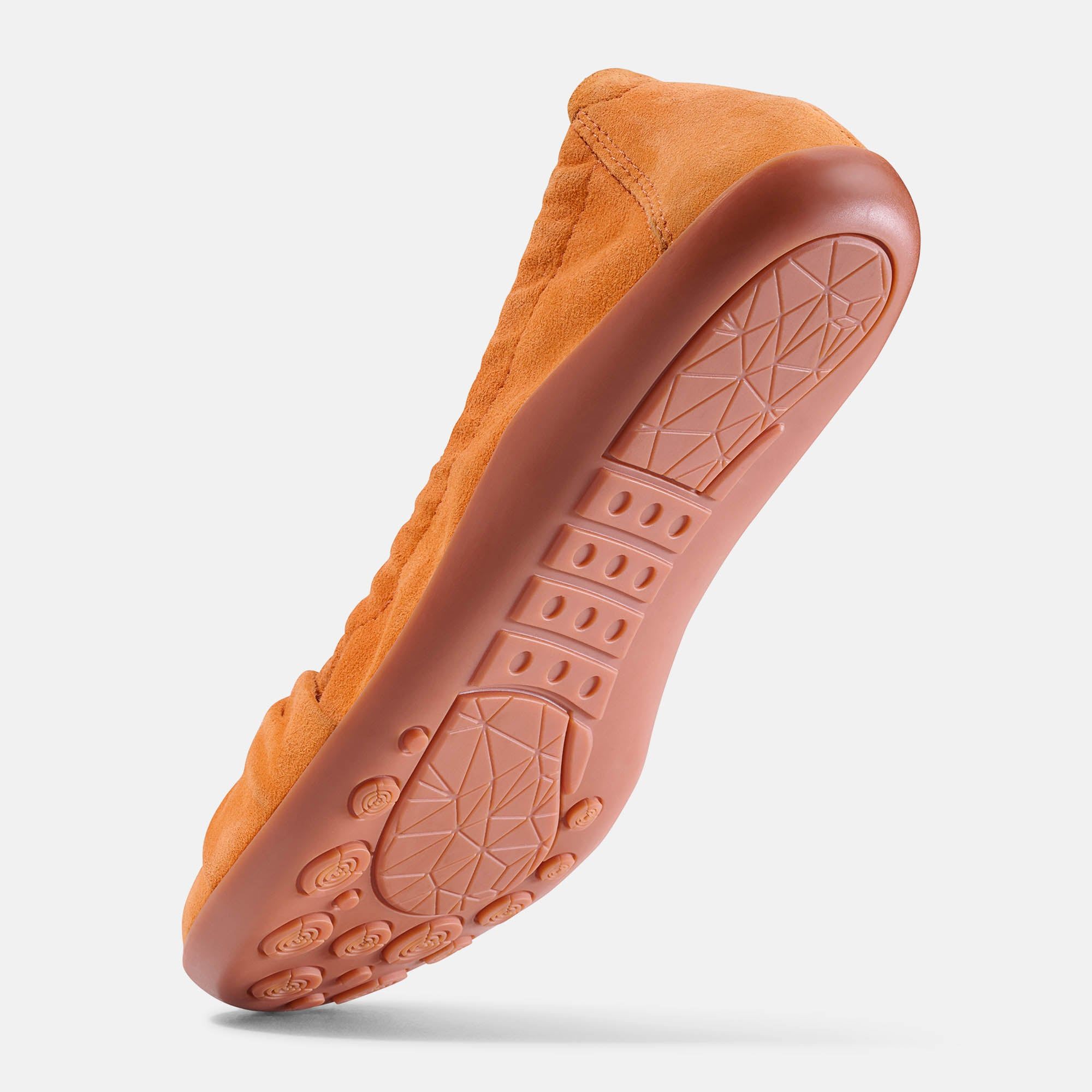Unterseite einer orangefarbenen Ballerina aus Wildleder. Rutschfeste Sohle mit Profil.
