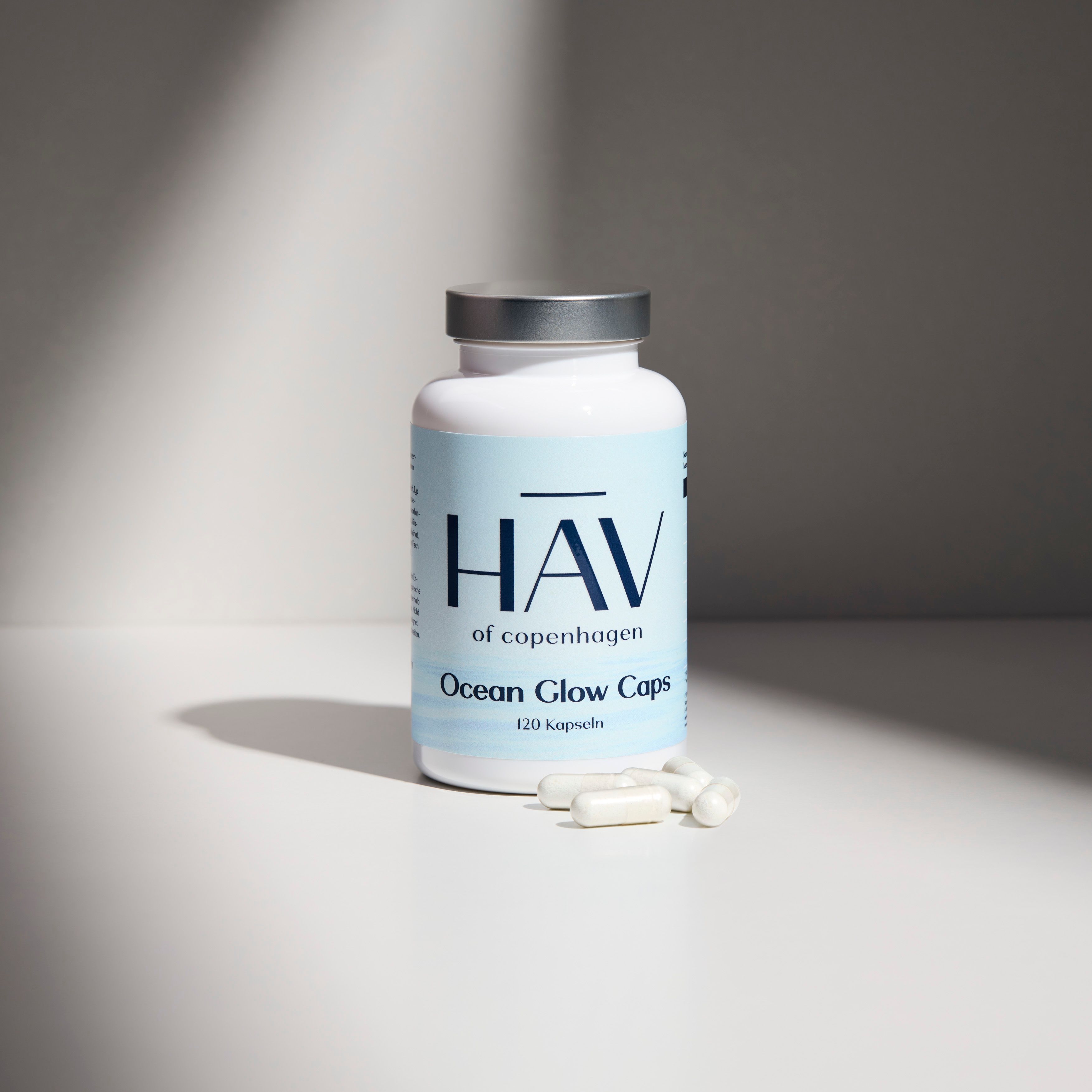 Weiße Flasche mit HAV-Logo und Aufschrift "Ocean Glow Caps 120 Kapseln". Kapseln daneben.