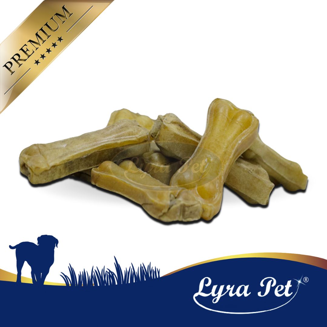 Mehrere gelbliche Kauknochen, ca. 7 cm, liegen auf weißem Grund. Logo: Lyra Pet.