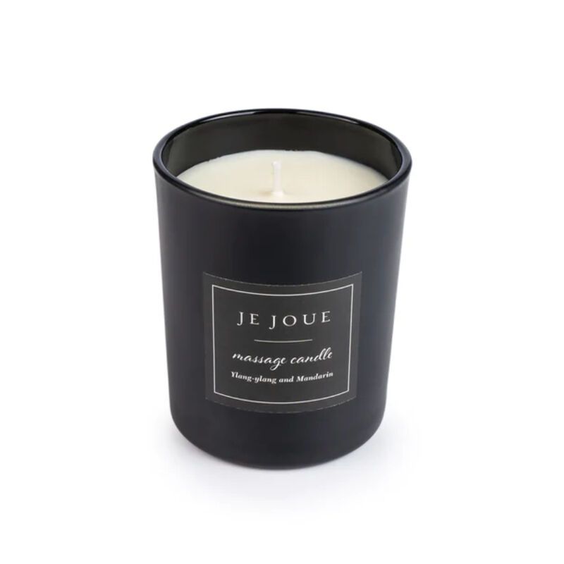 Schwarze Kerze im Glas mit Aufschrift "JE JOUE massage candle". Text: Ylang-Ylang and Mandarin.