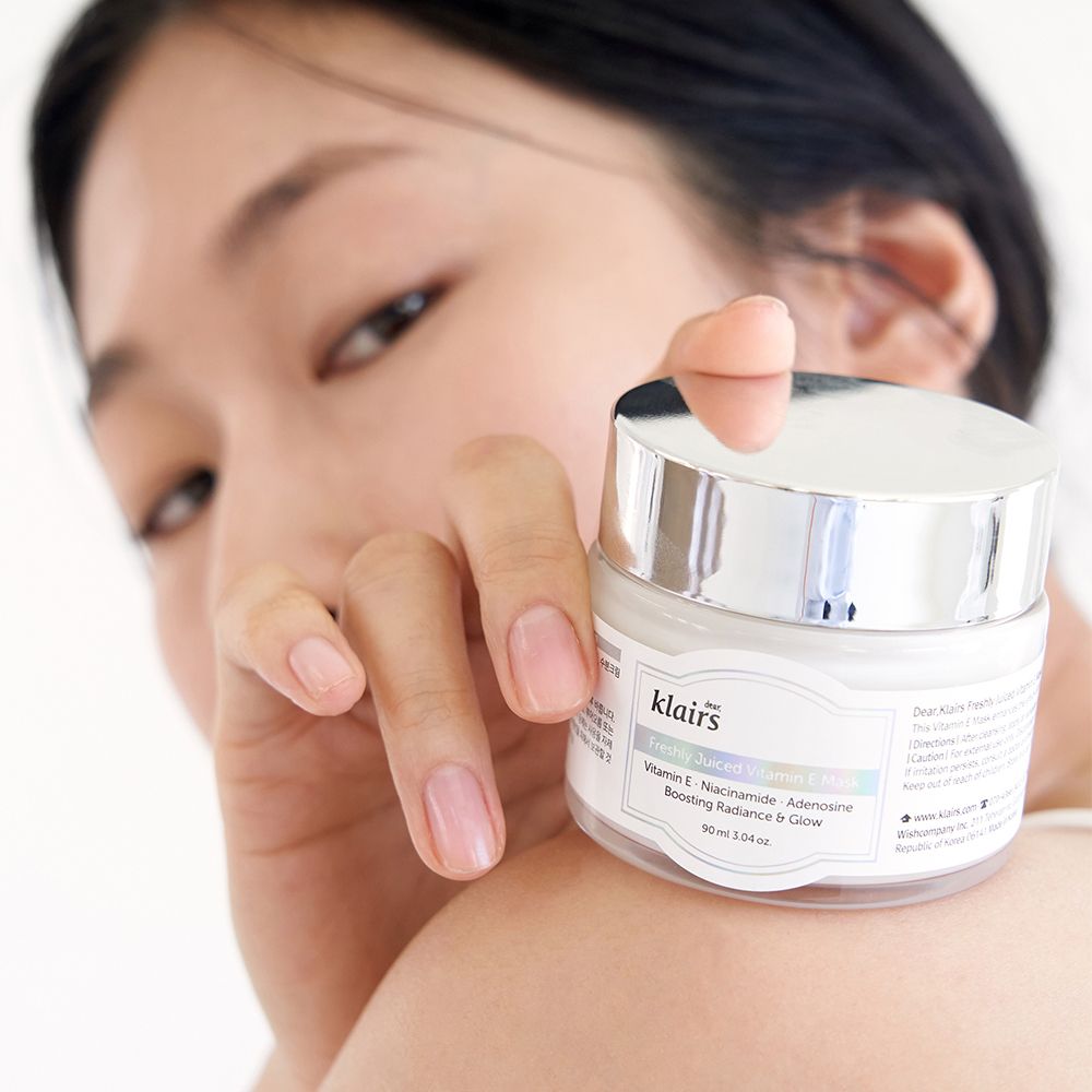 Frau hält Creme-Tiegel. Aufschrift: Freshly Juiced Vitamin E Mask.