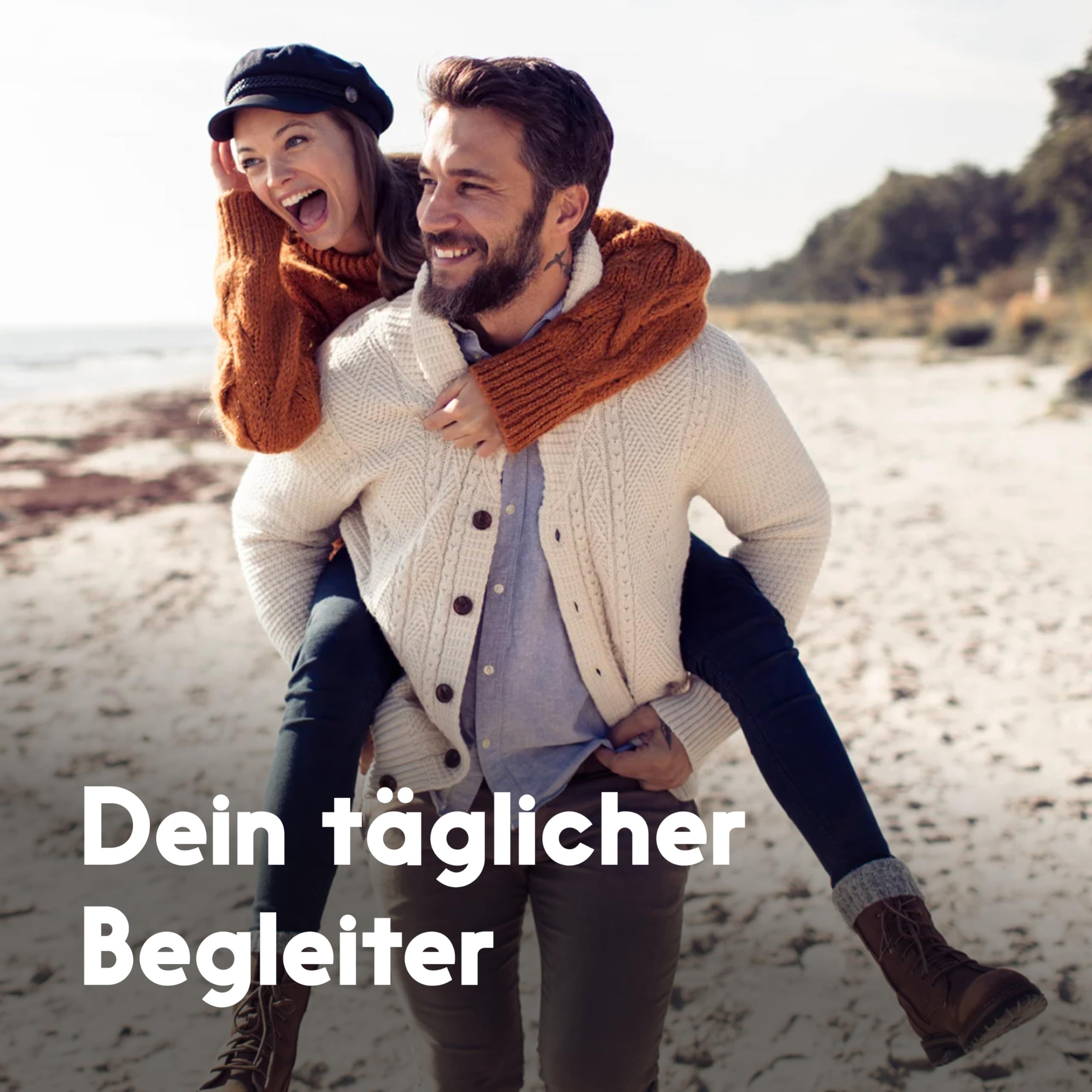 Ein Mann trägt eine Frau auf dem Rücken am Strand. Text: Dein täglicher Begleiter.