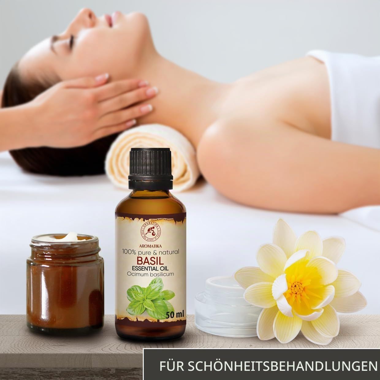Frau erhält eine Nackenmassage, daneben eine Flasche Basilikumöl und ein Glas.