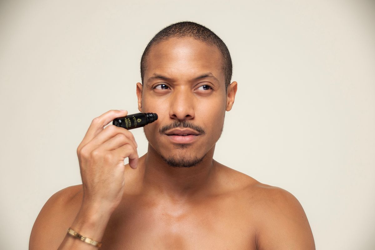 Ein Mann hält eine Lagalene Milano Ultra Intensive Care Flasche mit Roll-on-Applikator an sein Gesicht. Auf der Flasche steht "ULTRA INTENSIVE TREATMENT".