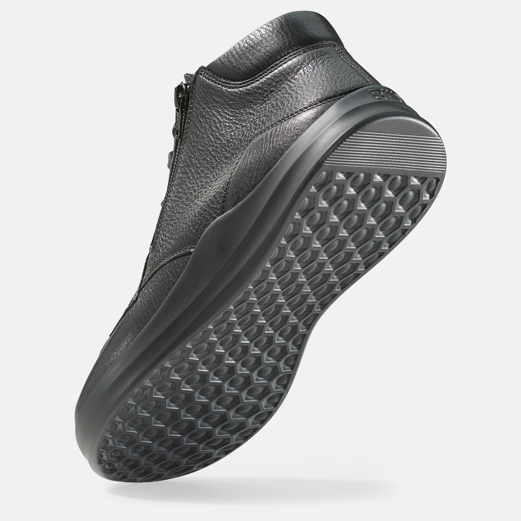 Schwarze Stiefelette von unten. Sohle mit Muster. Lederstruktur.