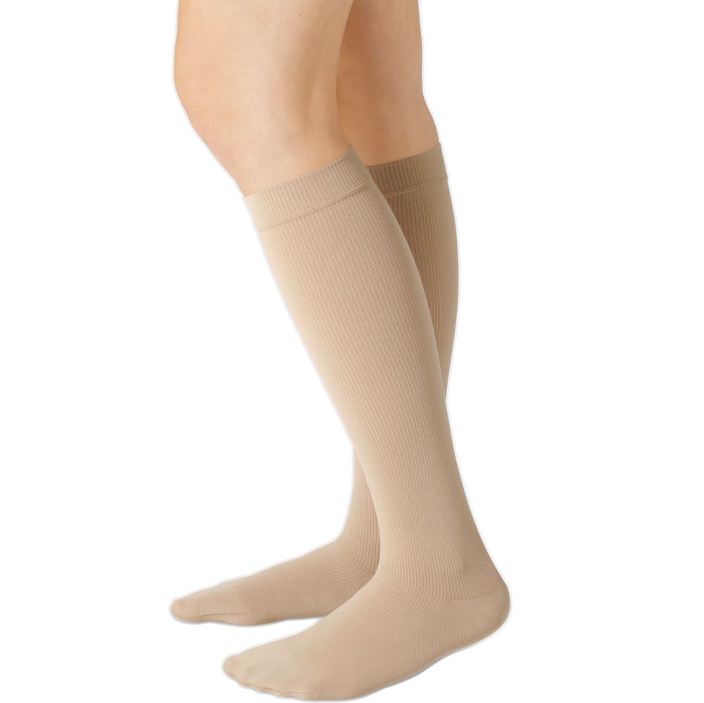 Beige Kompressionsstrümpfe, Kniestrümpfe, geripptes Material, Noppenhaftrand. Seitliche Ansicht, auf Beinen getragen.