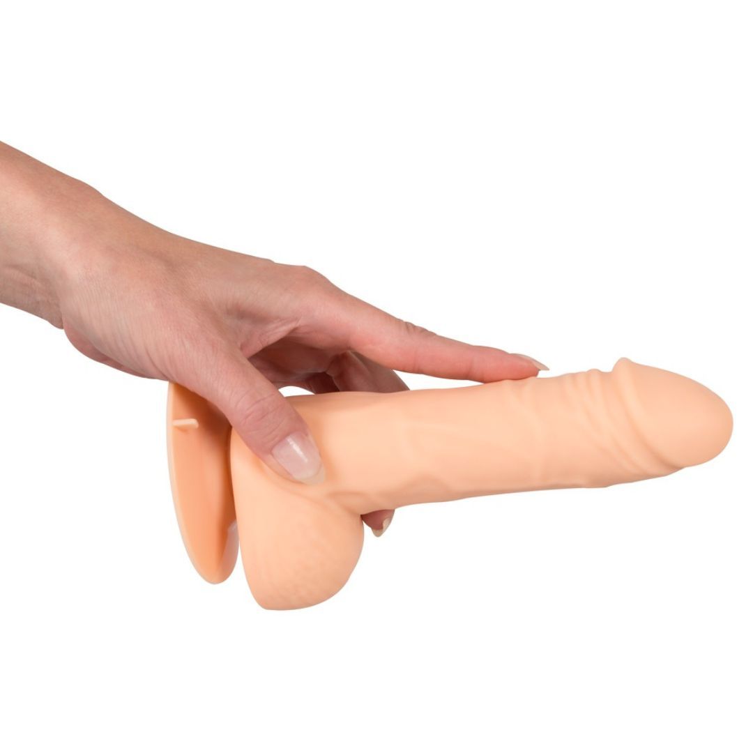 Beigefarbener Silikon-Vibrator, gehalten von einer Hand. Der Vibrator hat eine längliche Form mit einer abgerundeten Basis.