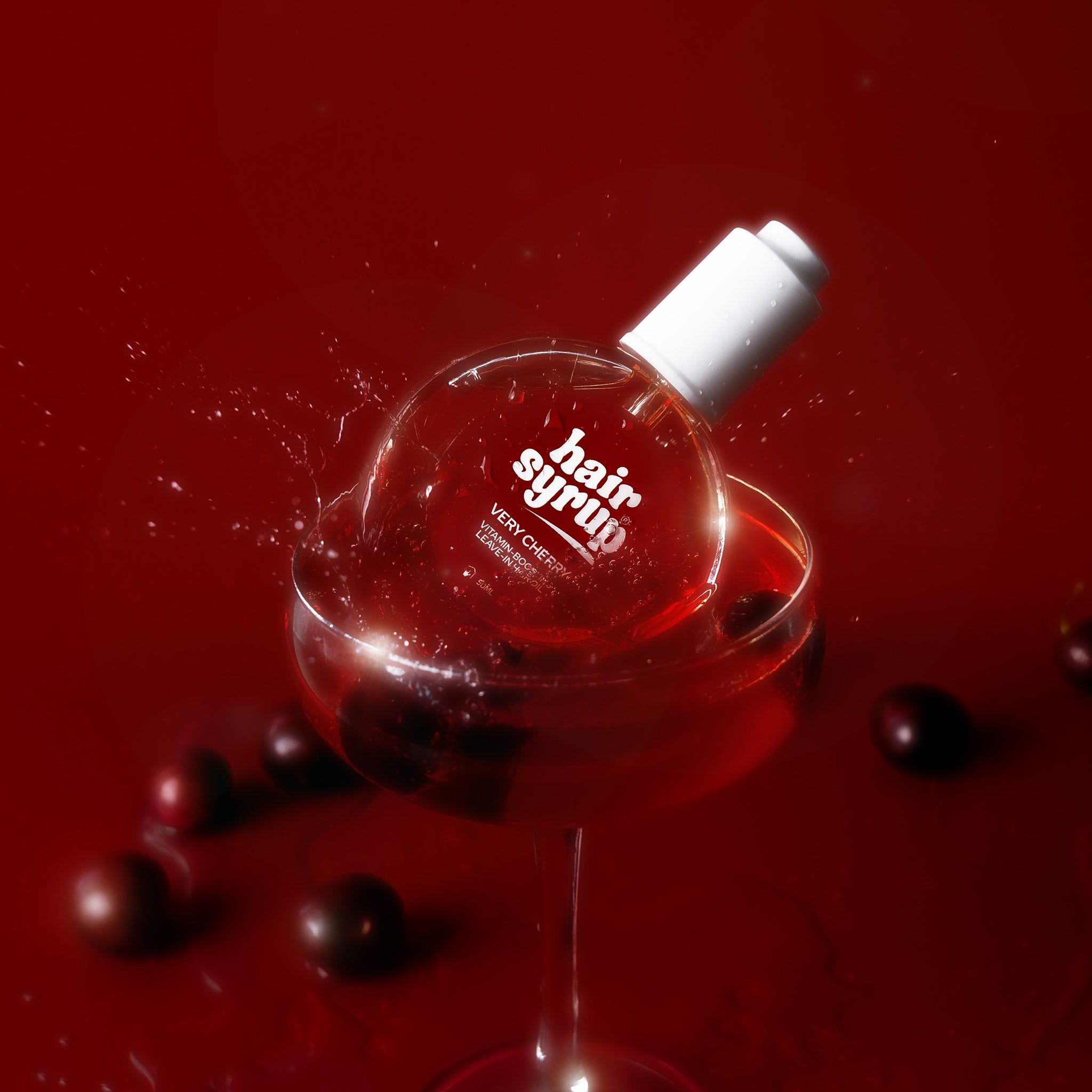 Runde Flasche in einem Weinglas mit Flüssigkeit. Kirschen und Flüssigkeitsspritzer. Rotes Etikett.