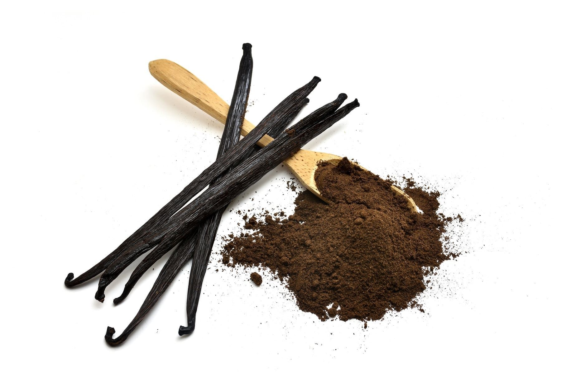 Vanilleschoten und gemahlenes Vanillepulver auf einem Holzlöffel. Auf weißem Hintergrund.