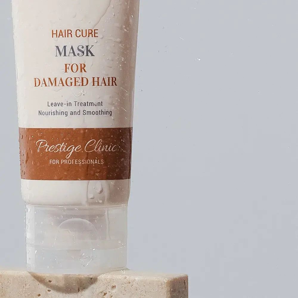 Creme-Tube mit Produktbeschriftung: HAIR CURE MASK FOR DAMAGED HAIR. Text: Leave-in Treatment, Nourishing and Smoothing. Prestige Clinic.