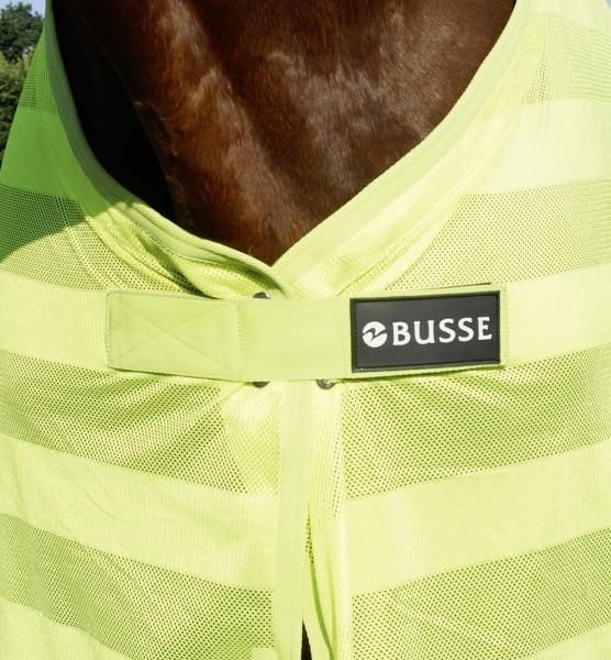 Nahaufnahme der Pferdedecke. Neongelbes Material mit Streifen. Schwarzes Etikett mit weißem BUSSE-Logo.