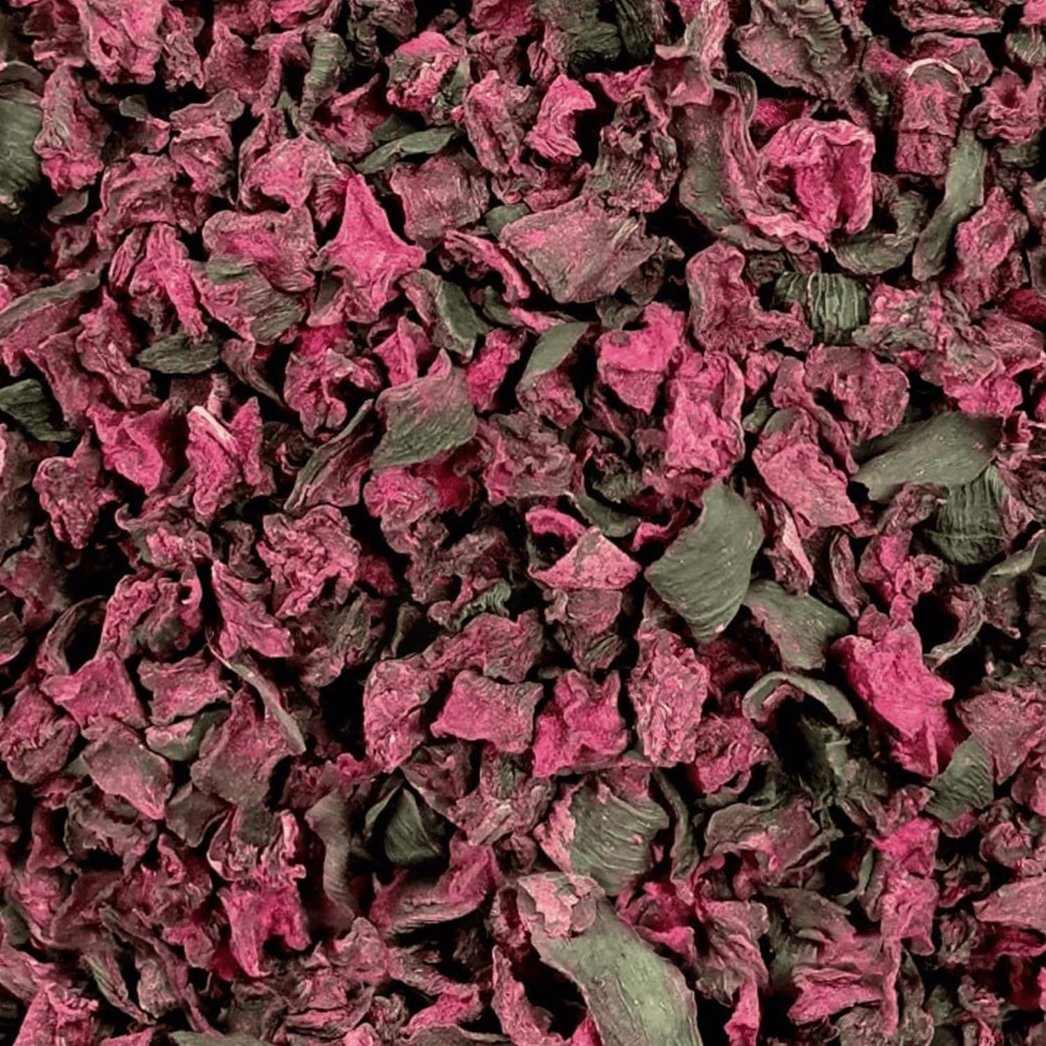 Gehackte, getrocknete Rote Bete. Rot-violette Farbe mit grünen Blattresten. Nahaufnahme.