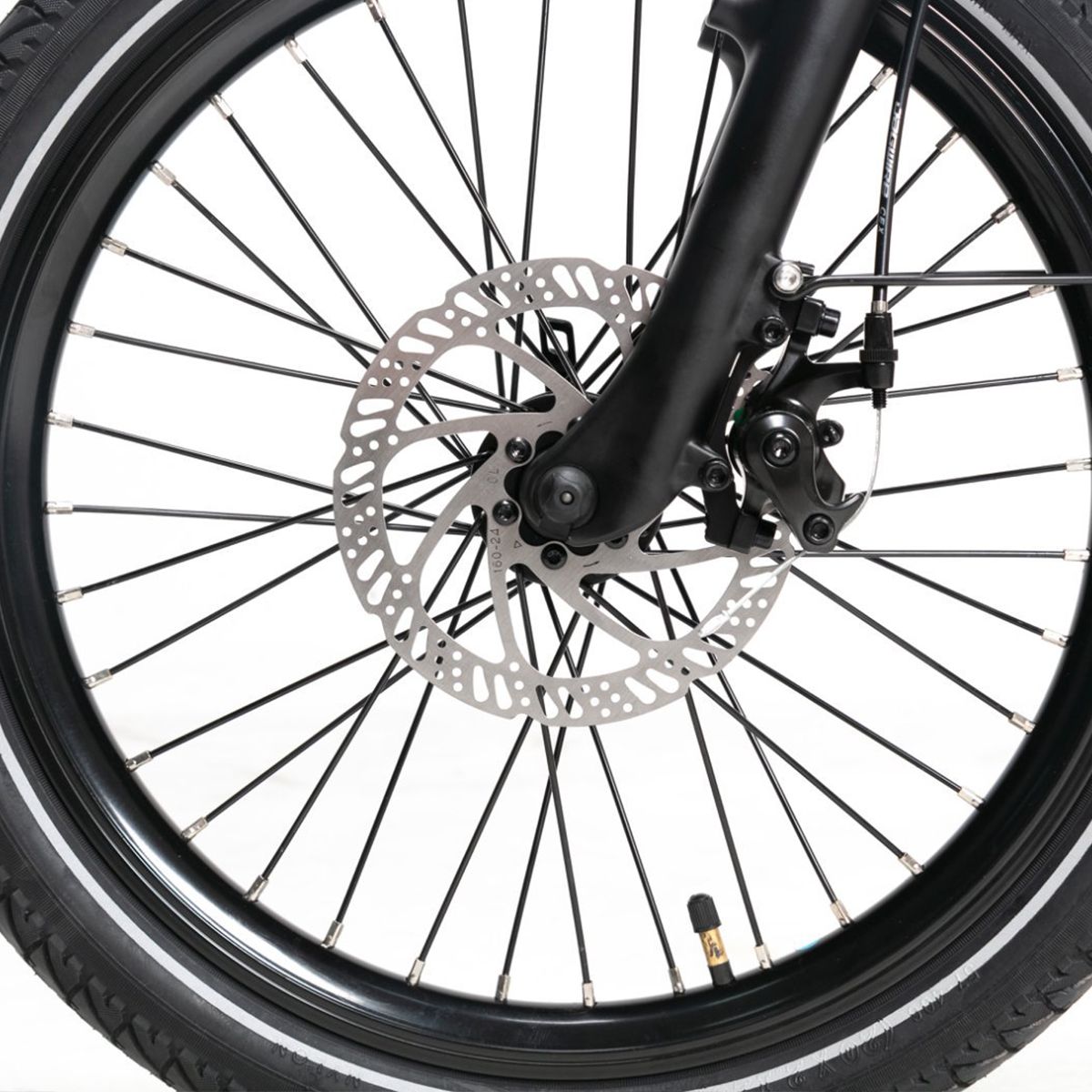 Vorderrad des E-Bikes. Schwarze Felge, Bremsscheibe und Speichen. Reifen mit weißem Streifen.