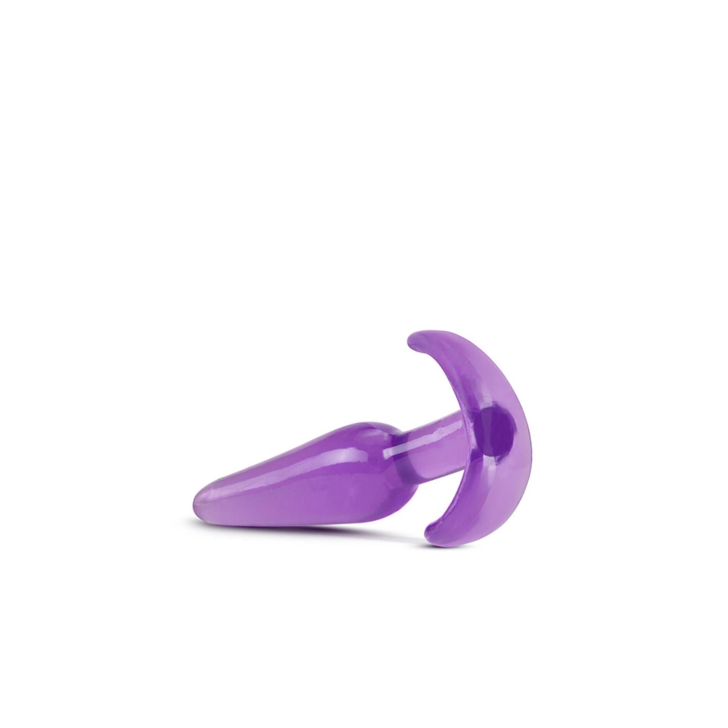 Lila Analplug. Konische Spitze, gebogene Basis. Liegend. Transparentes Material.