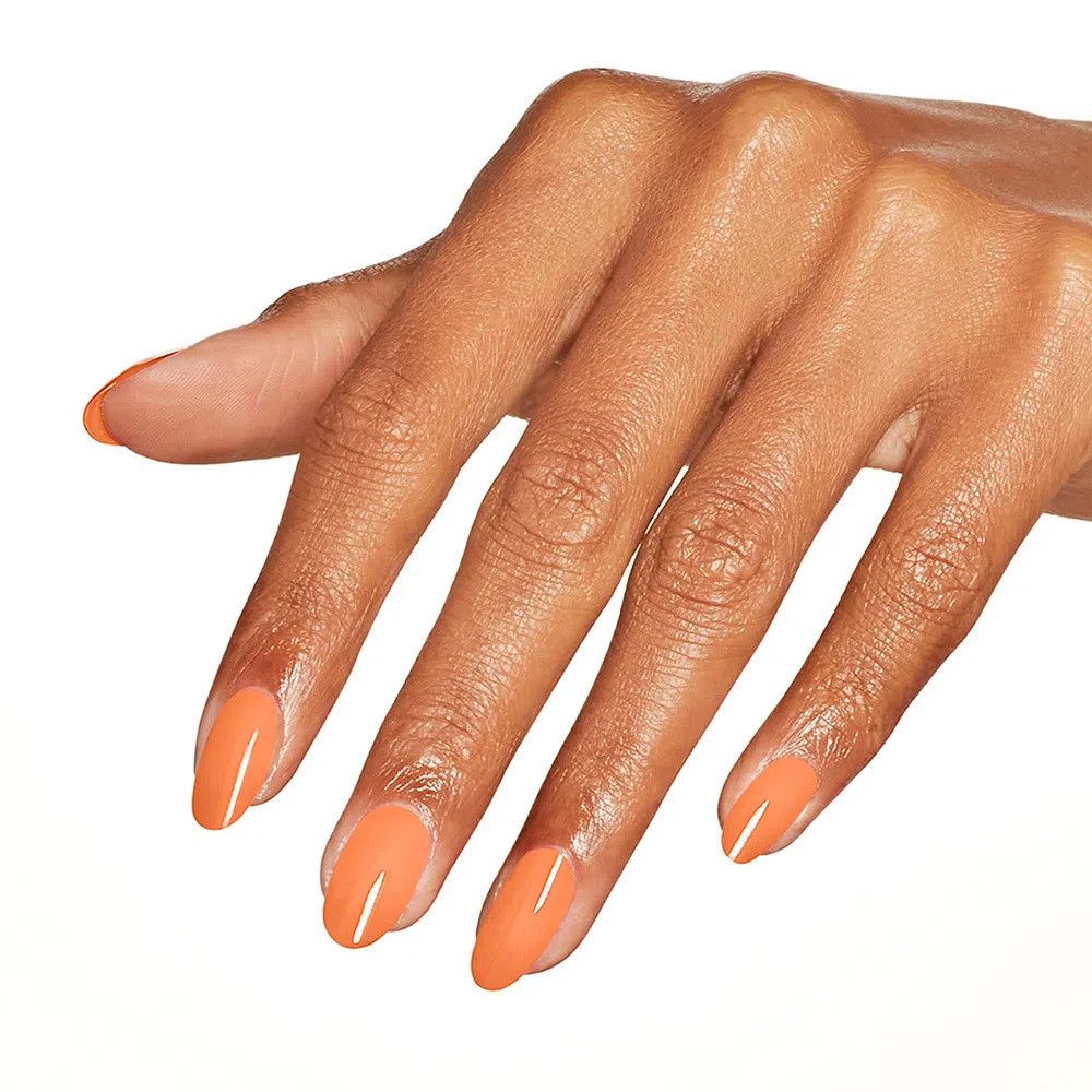 Hand mit perfekt manikürten Nägeln, lackiert in einem leuchtenden Orangeton.
