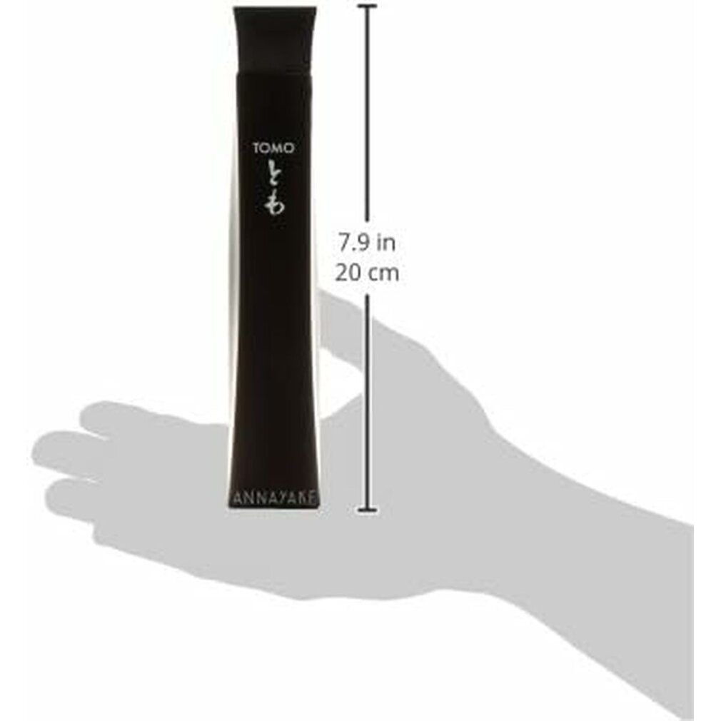 Schwarze Flasche mit quadratischem Deckel. Aufschrift TOMO und ANNNAYAKE. Japanische Schriftzeichen. Hand hält Flasche.