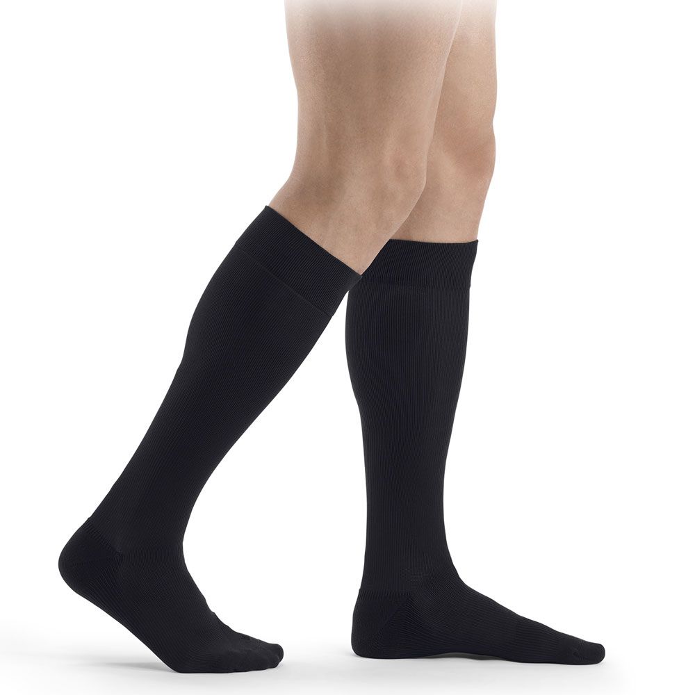 Schwarze Kompressionsstrümpfe bis zum Knie, an einem Mann getragen, Seitenansicht.