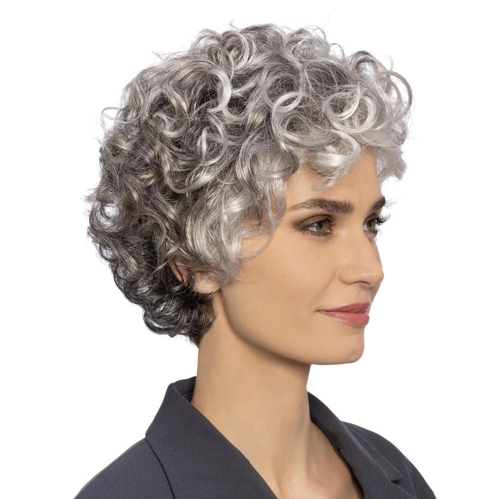 Perücke mit lockigem, grauem Haar. Die Frau trägt einen dunklen Blazer. Dreiviertelansicht.