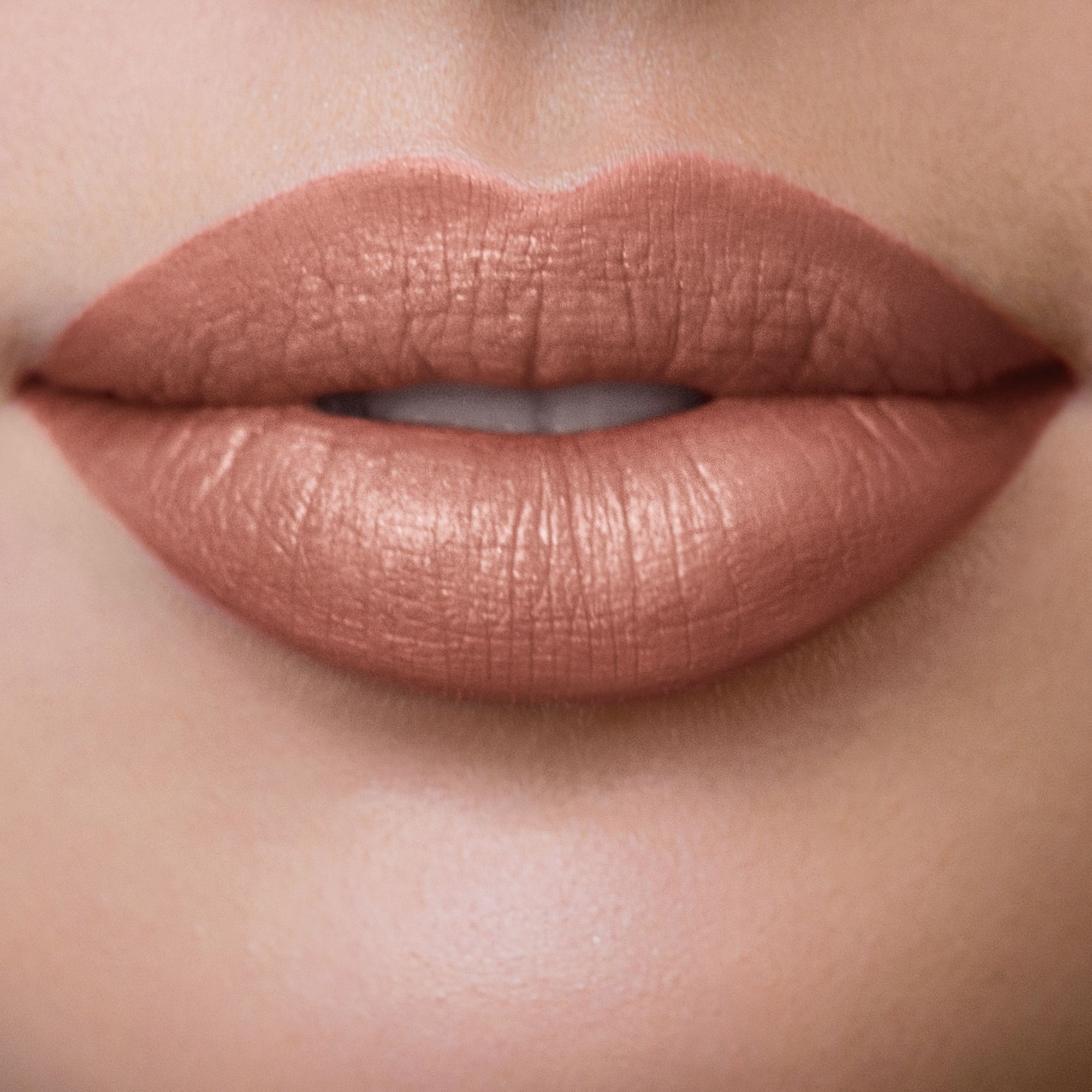 Nahaufnahme von Lippen, die mit rosabraunem Lippenstift geschminkt sind.