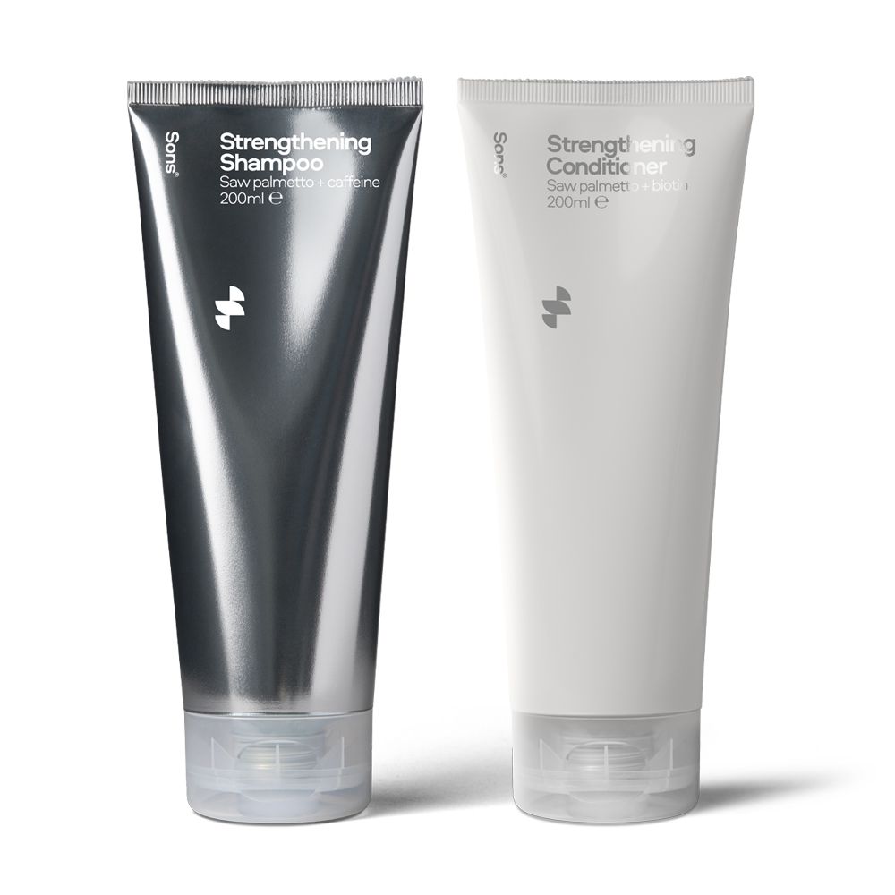 Zwei Tuben Shampoo und Spülung. Eine silberfarbene Tube mit der Aufschrift "Strengthening Shampoo". Eine weiße Tube mit "Strengthening Conditioner".