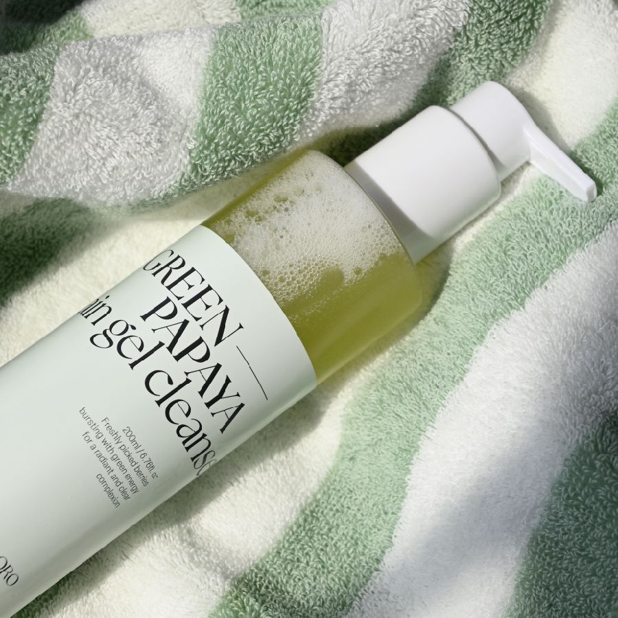 Flasche mit Pumpe auf einem Handtuch. Aufschrift: GREEN PAPAYA in gel cleans. Text: 200ml e. Marke: CHLORO.