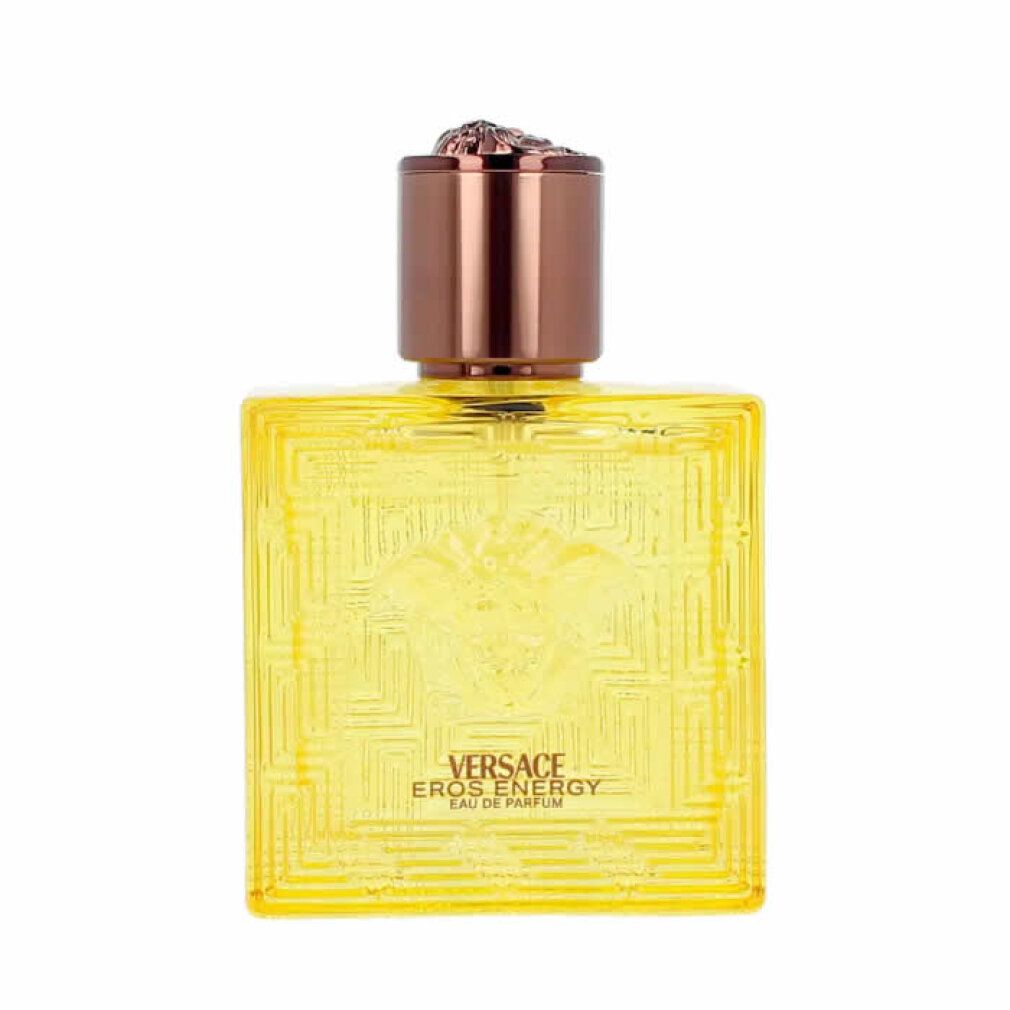 Gelber Flakon Versace Eros Energy. Brauner Verschluss. Quadratische Form mit Reliefmuster. Versace-Logo sichtbar.