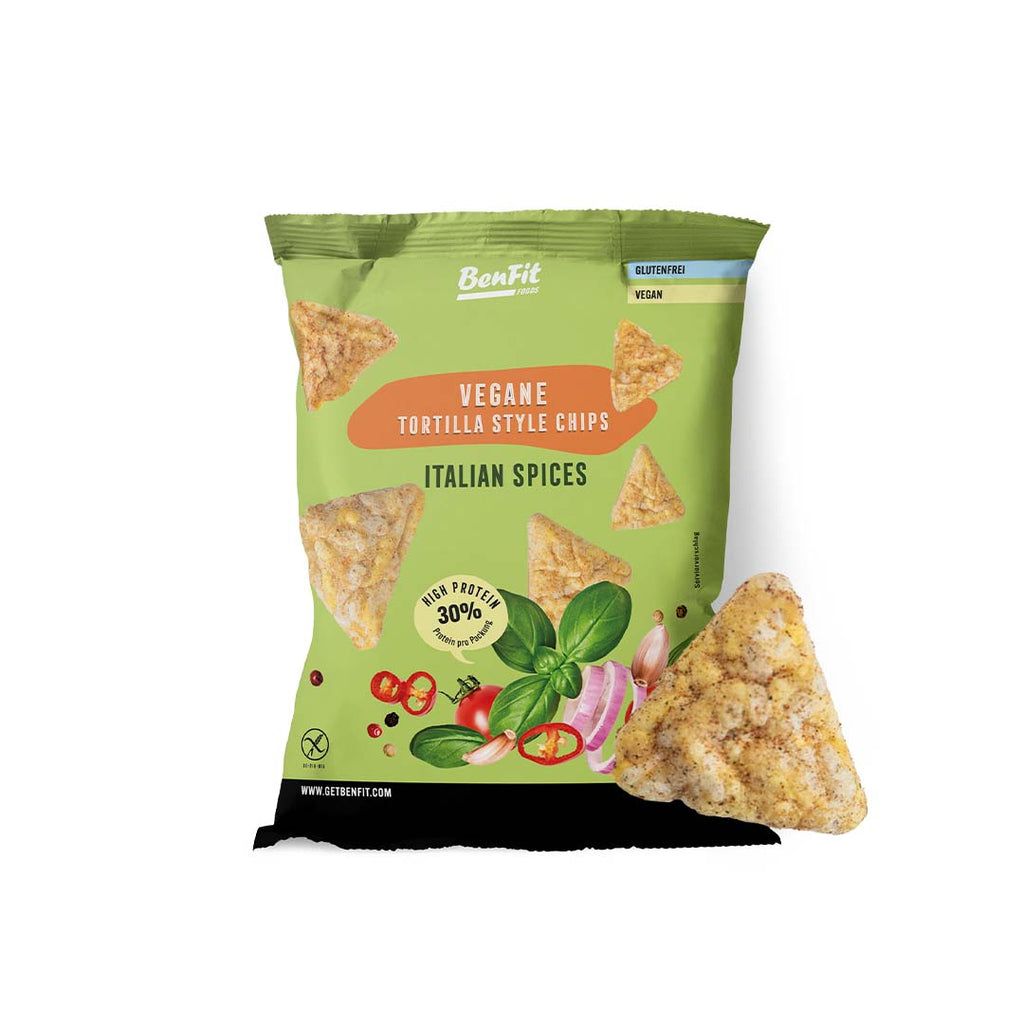 Grüne Tüte mit veganen Tortilla-Chips. Aufschrift: Italian Spices, hoher Proteingehalt. Einzelner Chip rechts.