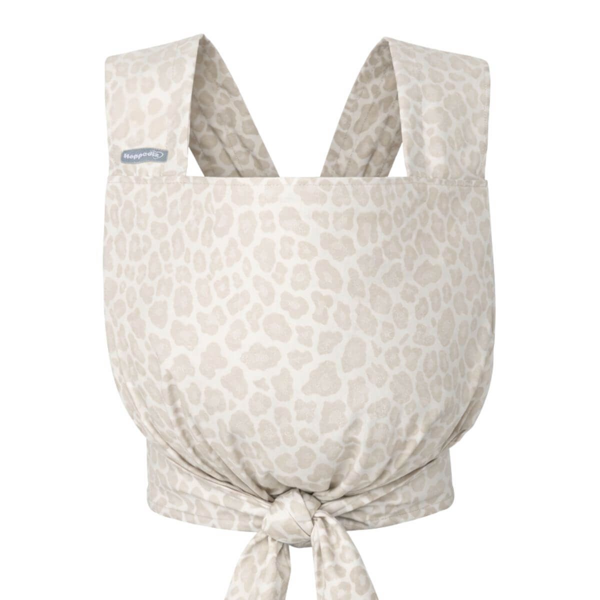 Puppentrage mit Leopardenmuster. Beige Stoff mit Trägern und Knoten. Label mit Schriftzug.