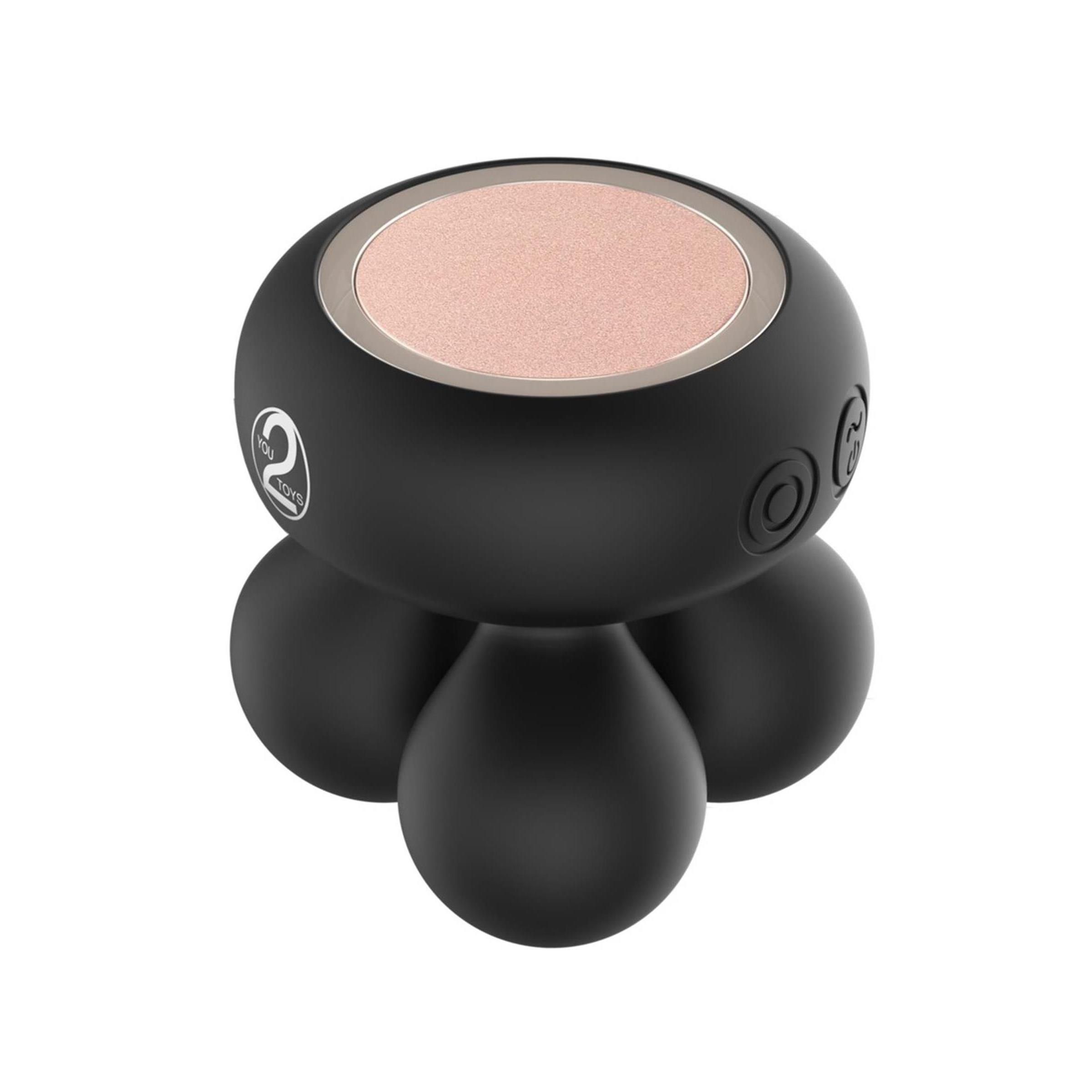 Schwarzes Massagegerät mit vier kugelförmigen Füßen und einer runden, hellen Oberfläche. Logo mit der Zahl 2.