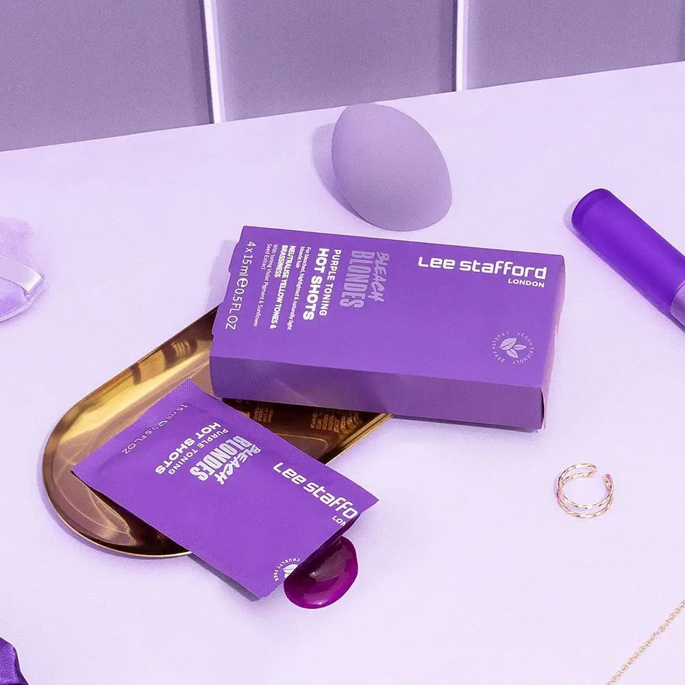 Produktverpackung und Beutel auf Tablett. Lila Farbton. Zusätzliche Kosmetikartikel.