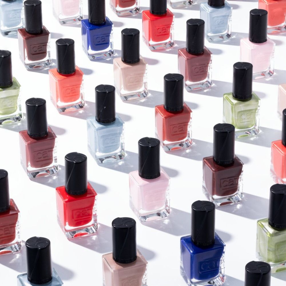 Mehrere Nagellackflaschen in verschiedenen Farben, aufgereiht.