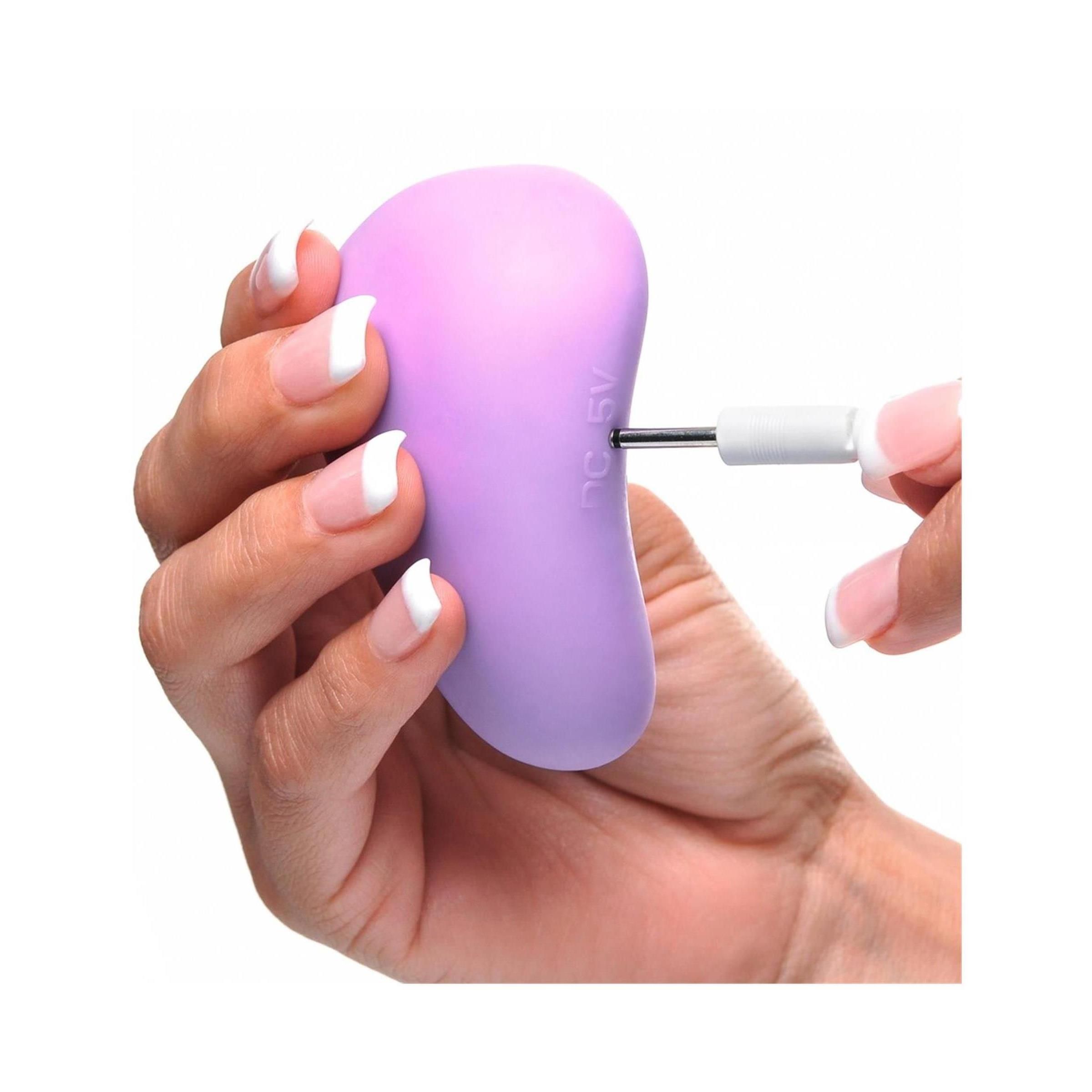 Lila Produkt, wird geladen. Hand hält Produkt und Stecker. Wellness-Produkt.