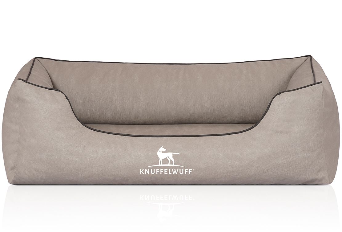 Beiges orthopädisches Hundebett mit schwarzer Umrandung. Logo: Knuffelwuff. Rechteckige Form mit erhöhten Seiten. Auf weißem Hintergrund.