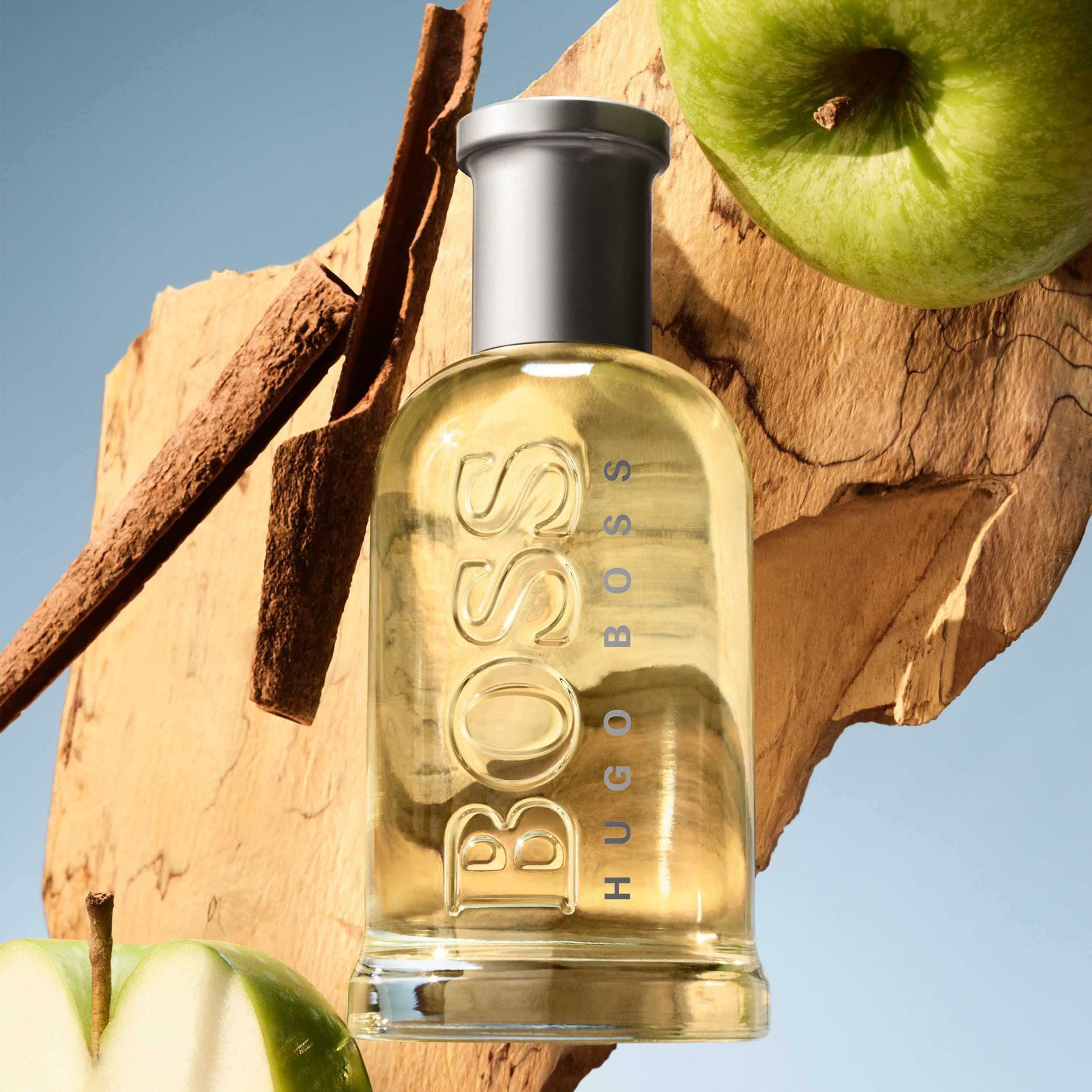 Hugo Boss Bottled Eau de Toilette Flakon mit Zimtstangen und Äpfeln.