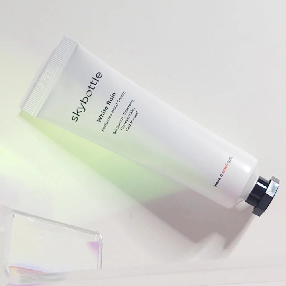 Weiße Tube mit schwarzem Verschluss. Aufschrift: skybottle, White Rain, Handcreme. Inhaltsstoffe: Bergamotte, Tuberose, Geißblatt, Zedernholz.