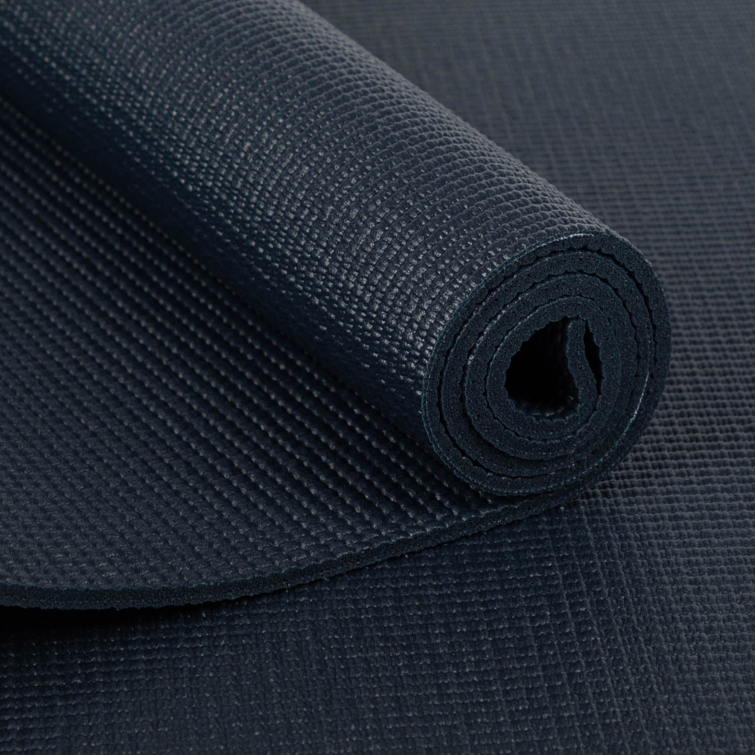 Gerollte dunkelblaue Yogamatte. Strukturierte Oberfläche. YANTRA/ALIGNMENT.
