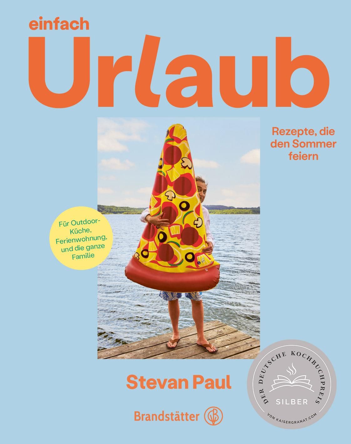 Buchcover mit Titel „einfach Urlaub“. Person hält Pizza-Schwimmreifen. Silberner Kochbuchpreis. Autor: Stevan Paul. Verlag: Brandstätter.