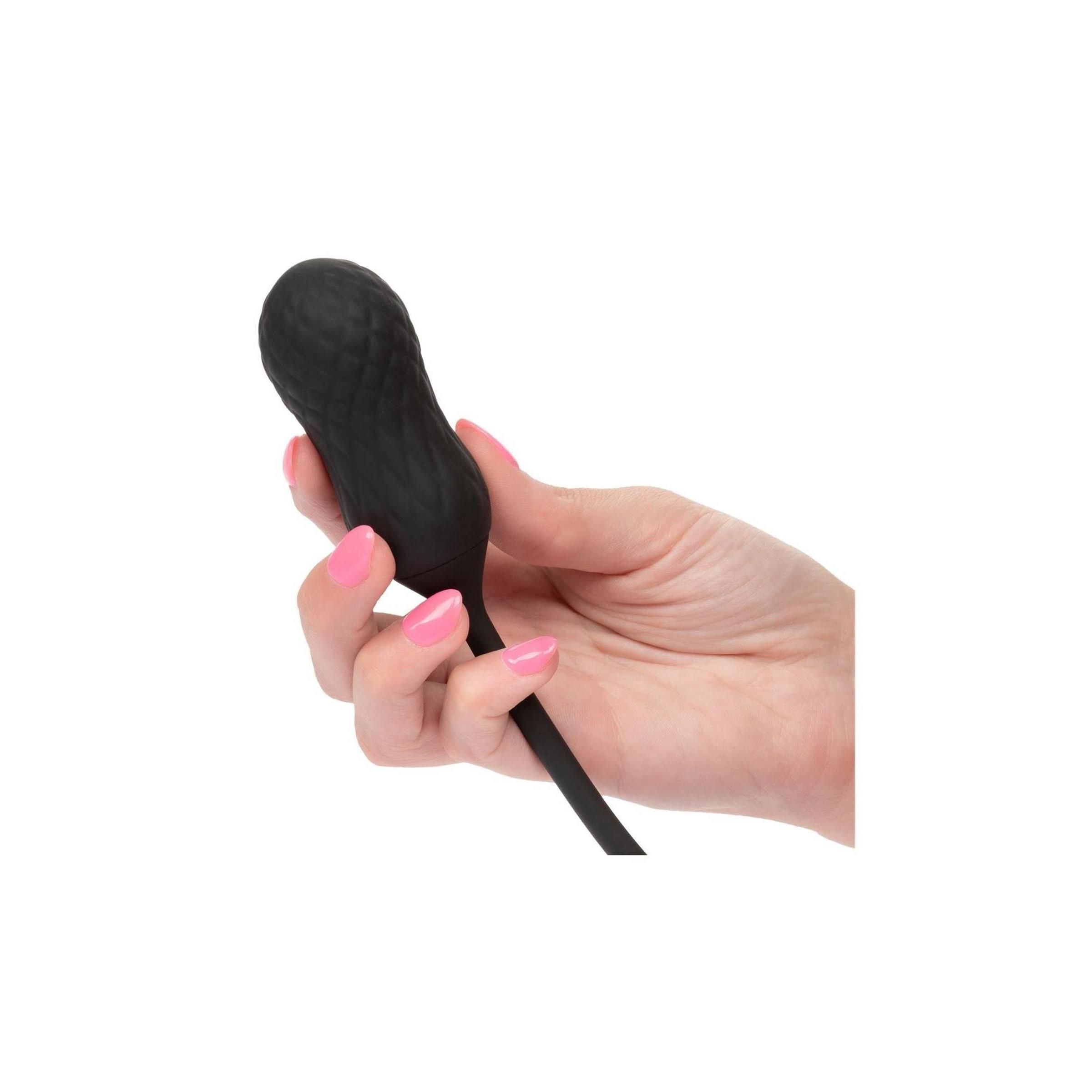 Schwarzes Wellness-Produkt in Hand. Gezeigt wird ein Vibrator mit geriffelter Oberfläche.