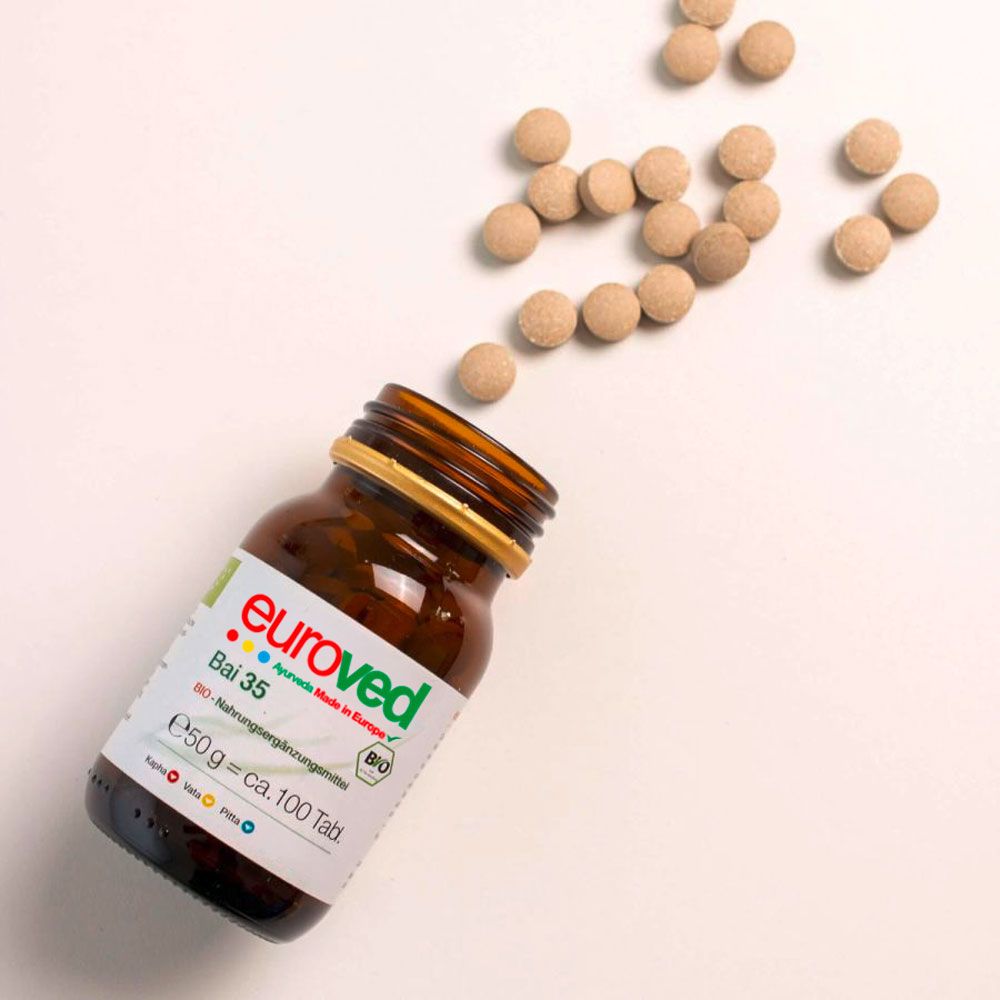 Braune Glasflasche, Tabletten daneben. Etikett mit Produktnamen und BIO-Siegel. Tabletten verstreut.