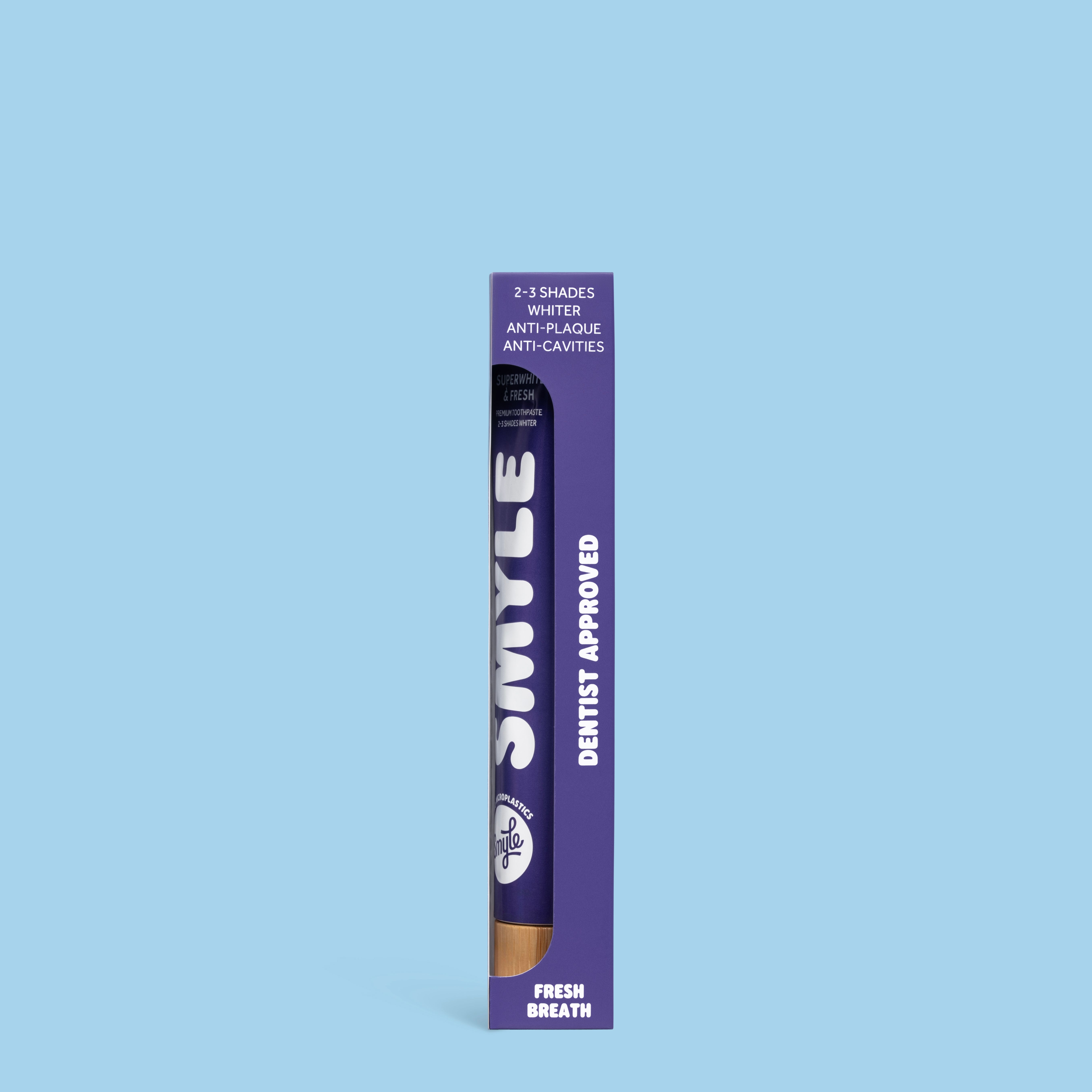 Lila Verpackung mit Zahnpasta-Tube. Aufschrift: SMYLE, Dentist Approved, Fresh Breath. 2-3 Shades Whiter.