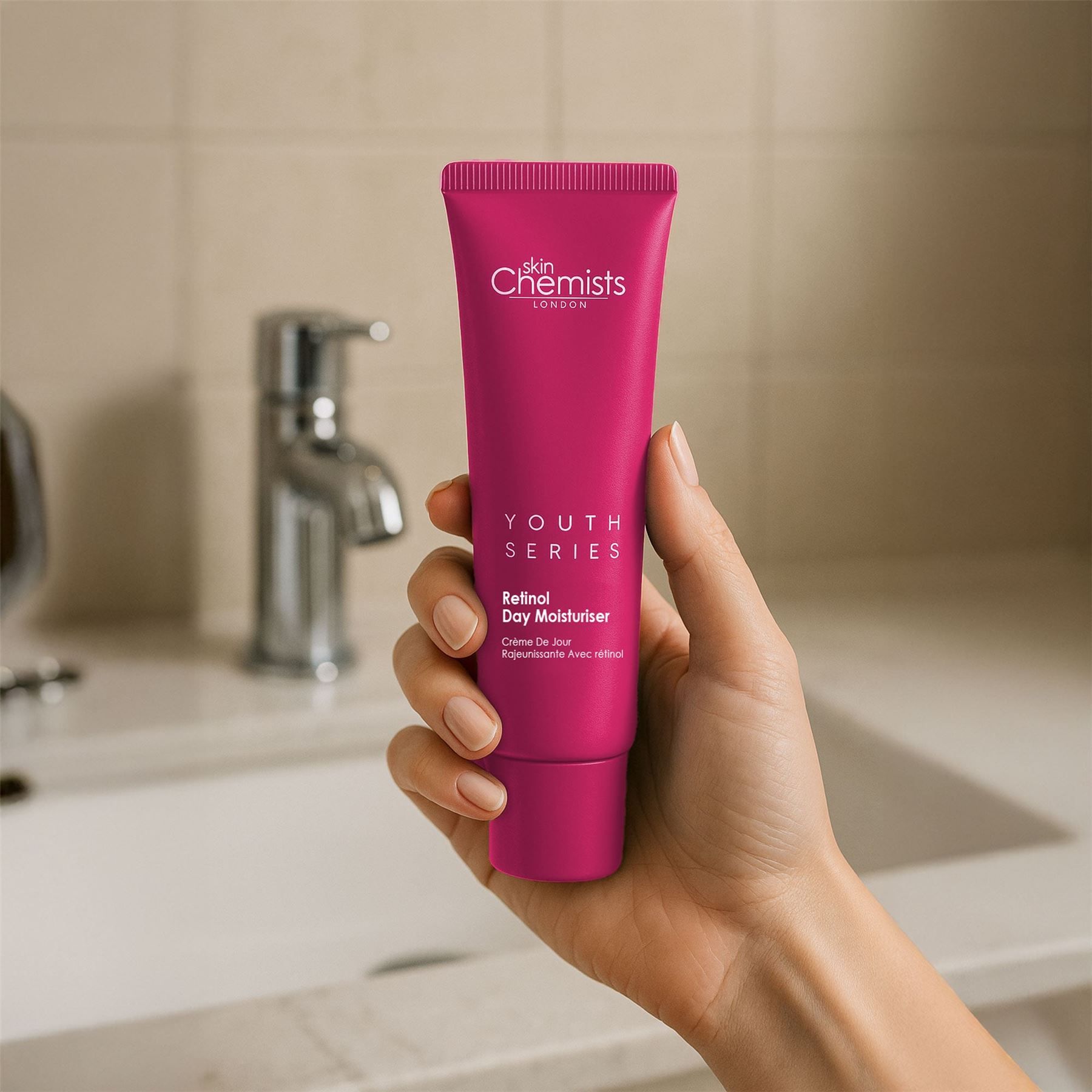 Hand hält eine Tube SkinChemists Retinol & Bakuchiol Tagescreme.