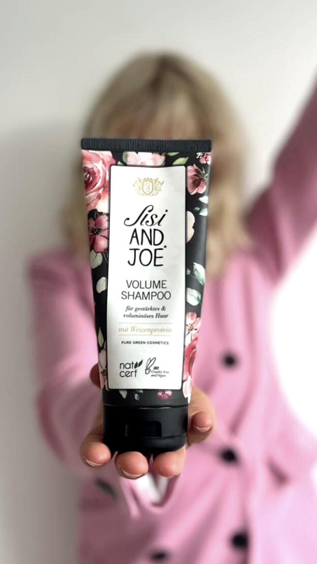 Schwarze Tube mit floralem Muster. Aufschrift: Sisi and Joe Volume Shampoo mit Weizenprotein. Natrue-Zertifizierung.